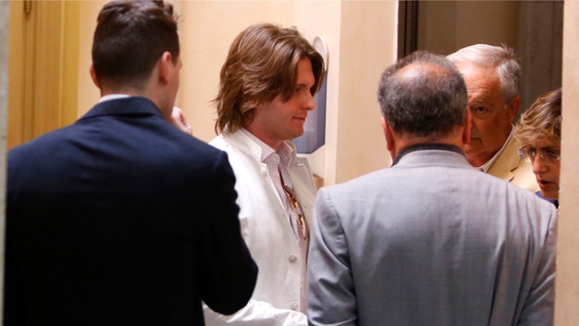 July 1, 2014: Raffaele Sollecito, second from left, and his father Francesco, second from right, listen to lawyers Luca Mauri, center with gray suit, and Giulia Bongiorno, right, before giving a press conference in Rome. (AP)