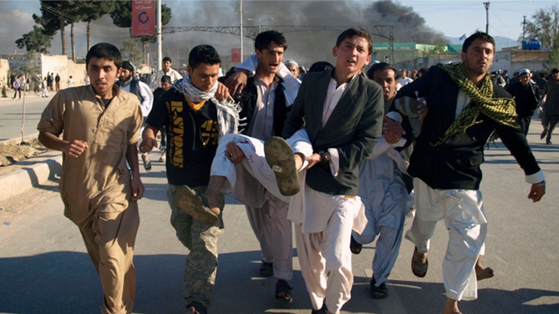 April 1: Afghans carry a man who was wounded following an attack on UN's office during a demonstration to condemn the burning of a copy of the Muslim holy book by a Florida pastor, in Mazar-i- Sharif north of Kabul, Afghanistan. An Afghan official says seven people have been killed at a U.N. office in the northern city of Mazar-i-Sharif when a Koran-burning protest turned violent. (AP)