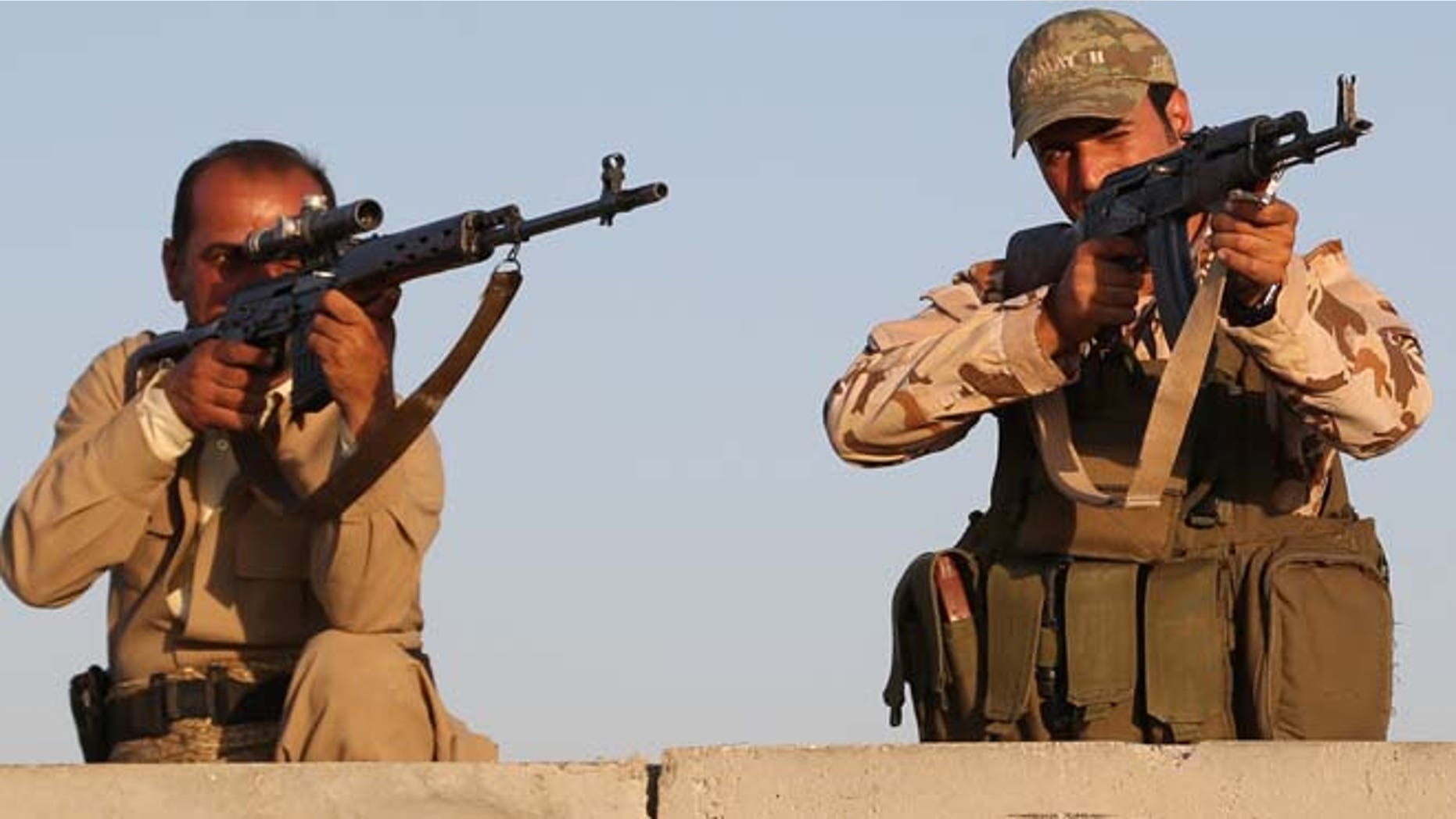 FILE: Aug. 8, 2014: Kurdish Peshmerga fighters during airstrikes targeting Islamic State militants outside of the city of Irbil in northern Iraq.