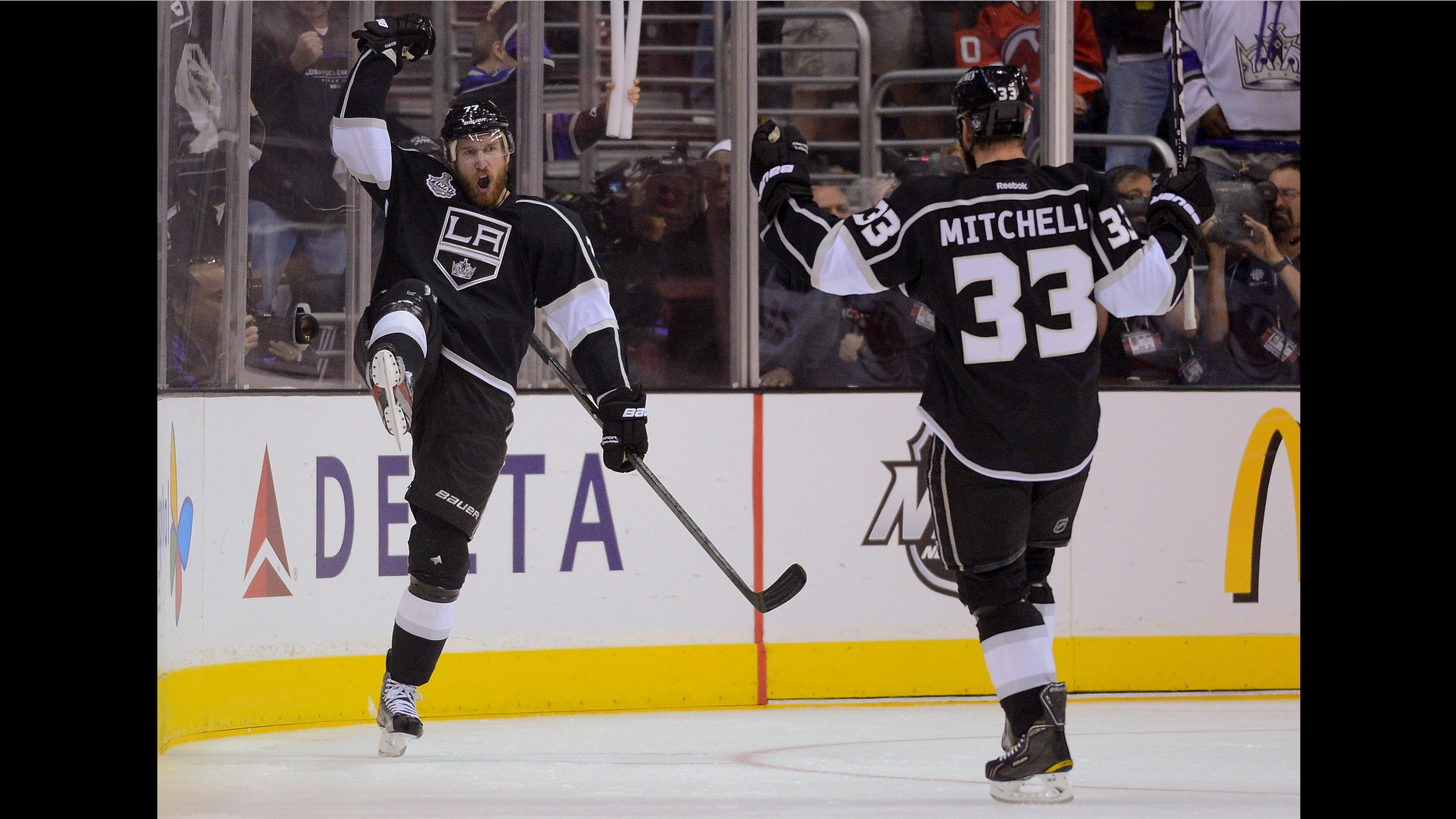 Los Angeles Kings center Jeff Carter (77) and Los Angeles Kings defenseman Willie Mitchell (33) react after Carter's third period goal against the New Jersey Devils during Game 3 of the Stanley Cup Finals, Monday, June 4, 2012, in Los Angeles. The Kings won 4-0. (AP Photo/Mark J. Terrill)