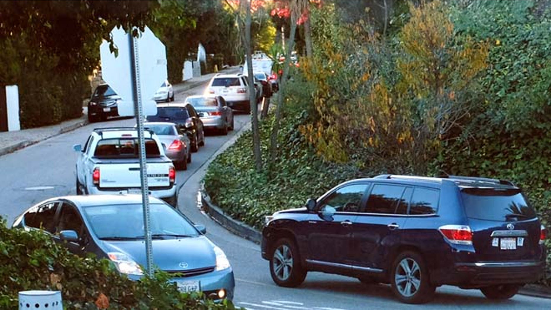 Dec. 9, 2014: Early morning rush hour traffic winds it's way along a narrow street in Sherman Oaks section of Los Angeles. When the people whose houses hug the narrow warren of streets paralleling the busiest urban freeway in America began to see bumper-to-bumper traffic rushing by their homes a year or so ago they were baffled. When word spread that the explosively popular new smartphone app Waze was sending many of those cars through their neighborhood in a quest to shave five minutes off a daily rush-hour commute, they were angry and ready to fight back.