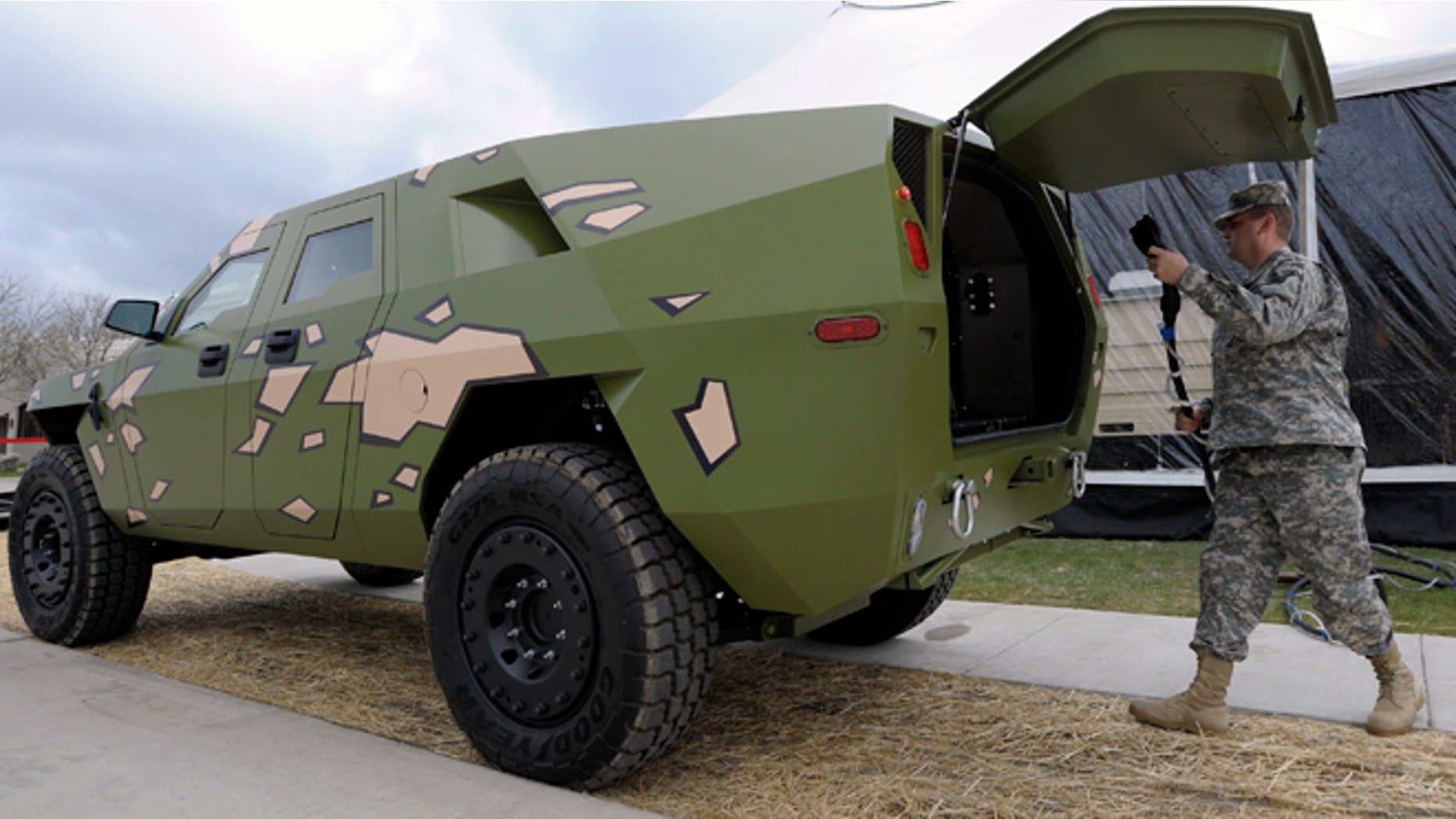 Captain Robert Shaw plugs a cord into this Fuel Efficient Demonstrator vehicle (FED) named, "BRAVO" to power electronics in the grand-opening tent, Wednesday, April 11, 2012 in Warren, Mich. The U.S. Army unveiled a new laboratory Wednesday that can simulate Afghanistan's desert heat and Antarctica's extreme cold in an effort to discover how to save energy and make combat vehicles fuel-efficient.