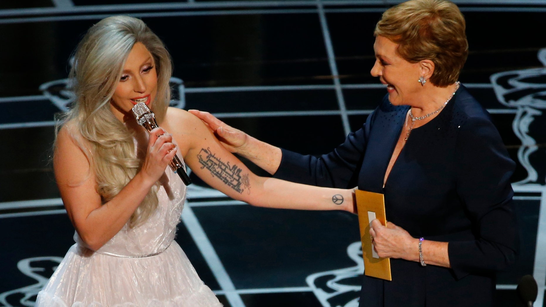 Singer Lady Gaga (L) pays tribute to Julie Andrews after performing songs from the Sound of Music at the 87th Academy Awards in Hollywood, California February 22, 2015. REUTERS/Mike Blake (UNITED STATES TAGS:ENTERTAINMENT) (OSCARS-SHOW) - RTR4QP5C