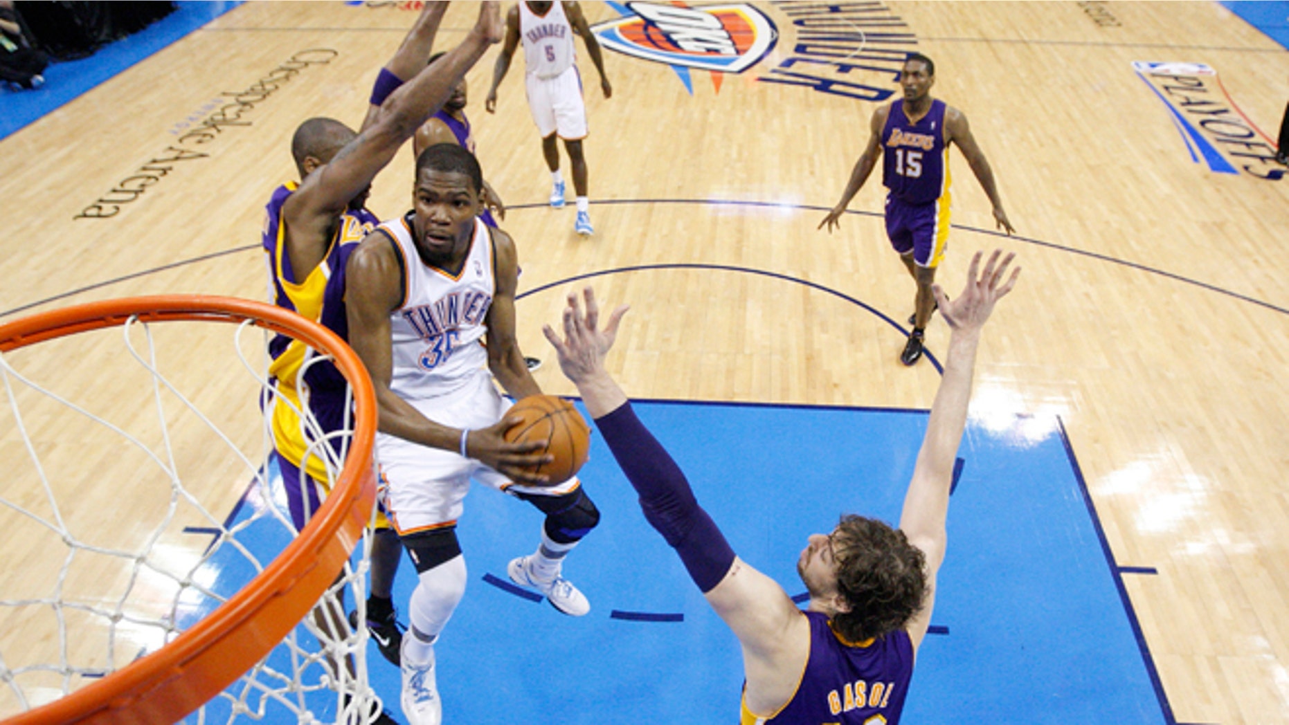 Oklahoma City Thunder forward Kevin Durant, center, goes up for a shot between Los Angeles Lakers guard Kobe Bryant, left and forward Pau Gasol (16) in the second quarter in Game 2 of an NBA basketball playoffs Western Conference semifinal, in Oklahoma City on Wednesday, May 16, 2012. Oklahoma City won 77-75. (AP Photo/Sue Ogrocki, Pool)