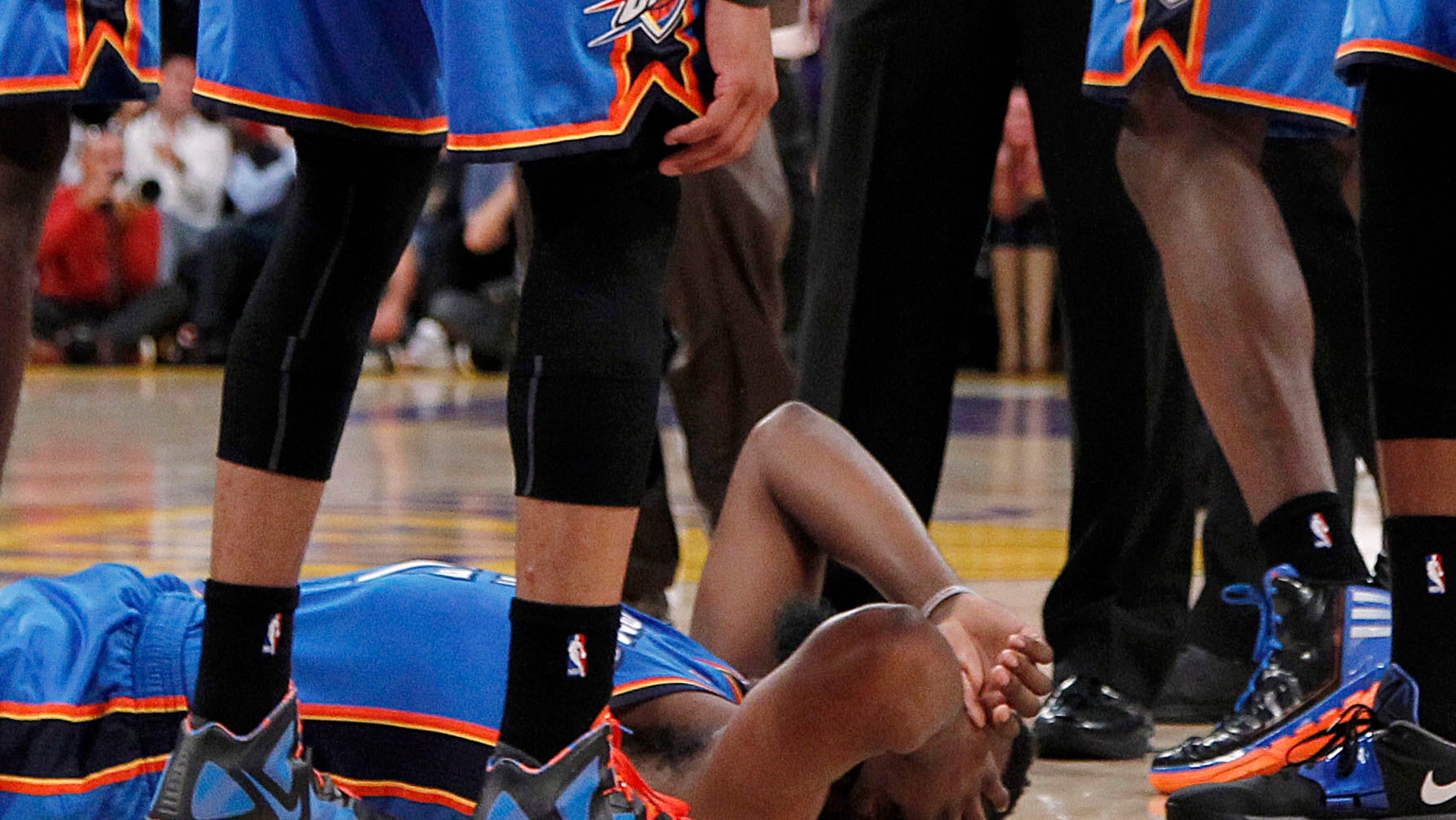 April 22: Oklahoma City Thunder players stand over teammate James Harden, lower left, after receiving a flagrant double foul from Los Angeles Lakers' Metta World Peace, who was then ejected, in the first half of an NBA basketball game in Los Angeles.
