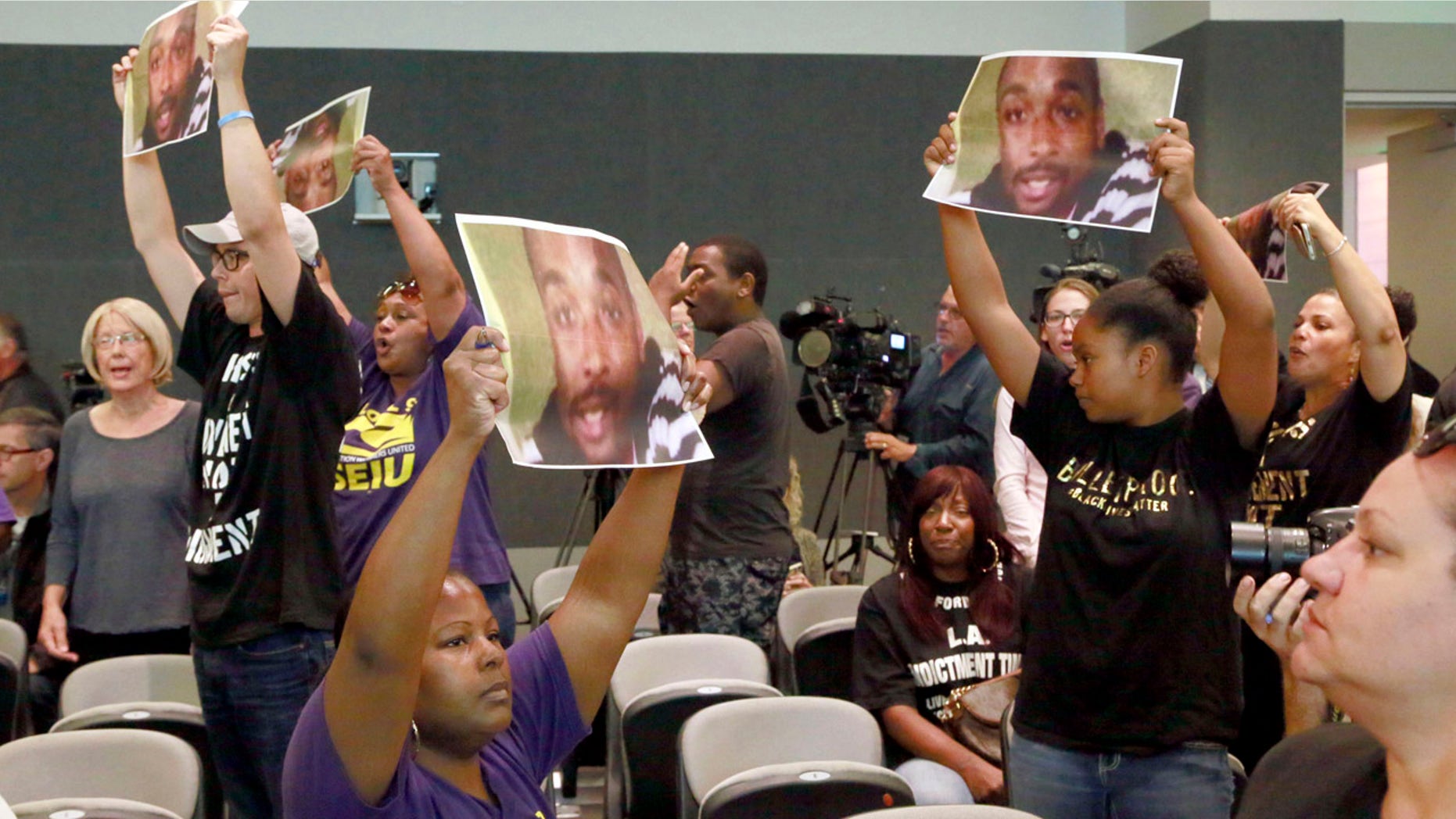 Aug. 11, 2015: Protesters holding photos of Ezell Ford, chant for Los Angeles Police Chief Charlie Beck's firing during a Los Angeles Police Commission meeting in downtown Los Angeles.