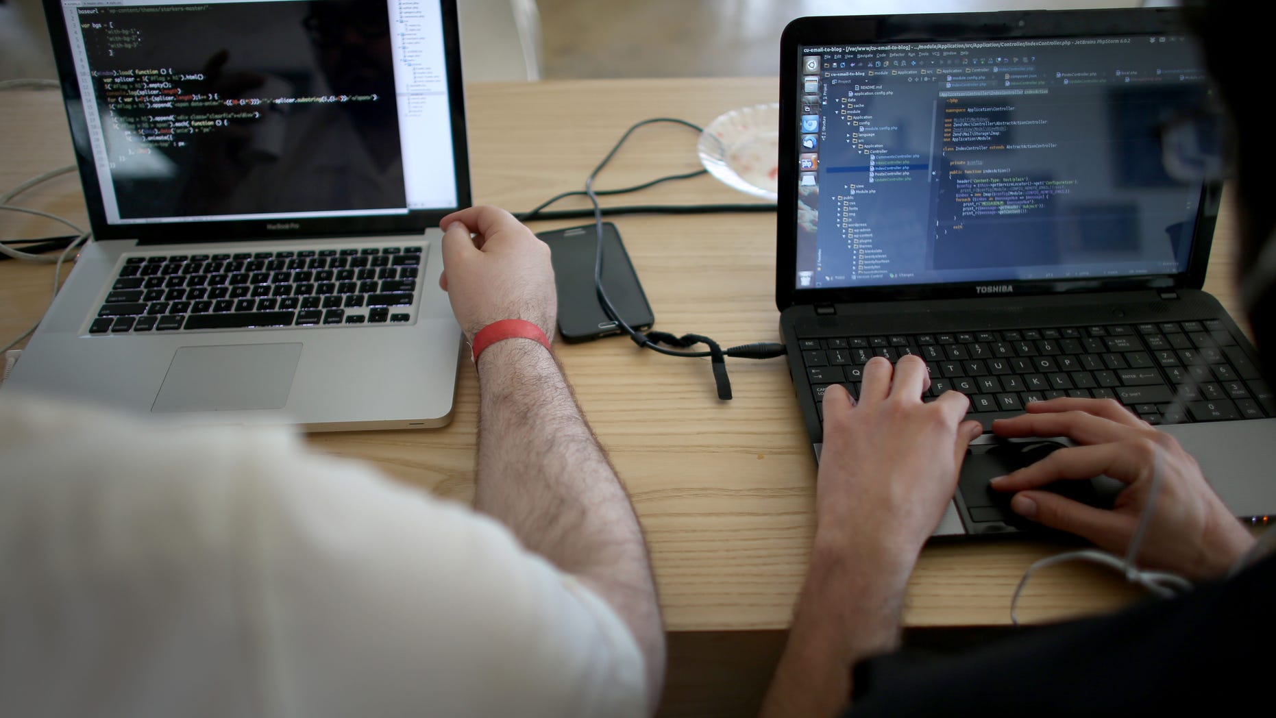 MIAMI, FL - FEBRUARY 01: Miguel Chateloin (R) and Lazaro Gamio use their computers to write code that would allow people living in Cuba to use email to post to blogs during the Hackathon for Cuba event on February 1, 2014 in Miami, Florida. The hackathon brought together experts and programmers to devise innovative technology solutions aimed at strengthening communications and information access in Cuba. The event is organized by Roots of Hope with support from the John S. and James L. Knight Foundation. (Photo by Joe Raedle/Getty Images)
