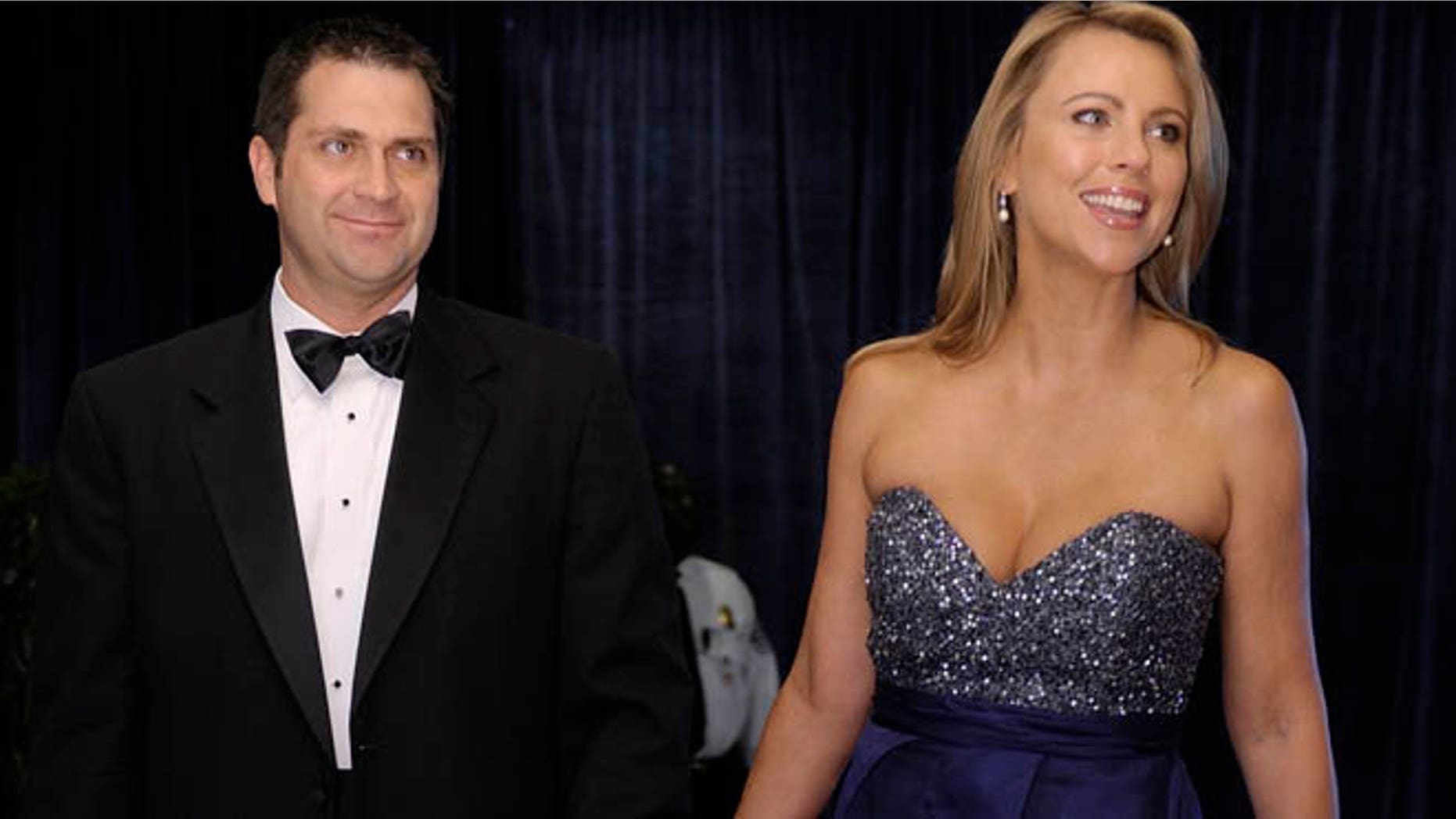 Lara Logan of CBS News and her husband Joseph Burkett stand on the red carpet as they arrive for the annual White House Correspondents' Association dinner in Washington, April 30, 2011. REUTERS/Jonathan Ernst (UNITED STATES - Tags: POLITICS ENTERTAINMENT MEDIA) - RTR2LU14