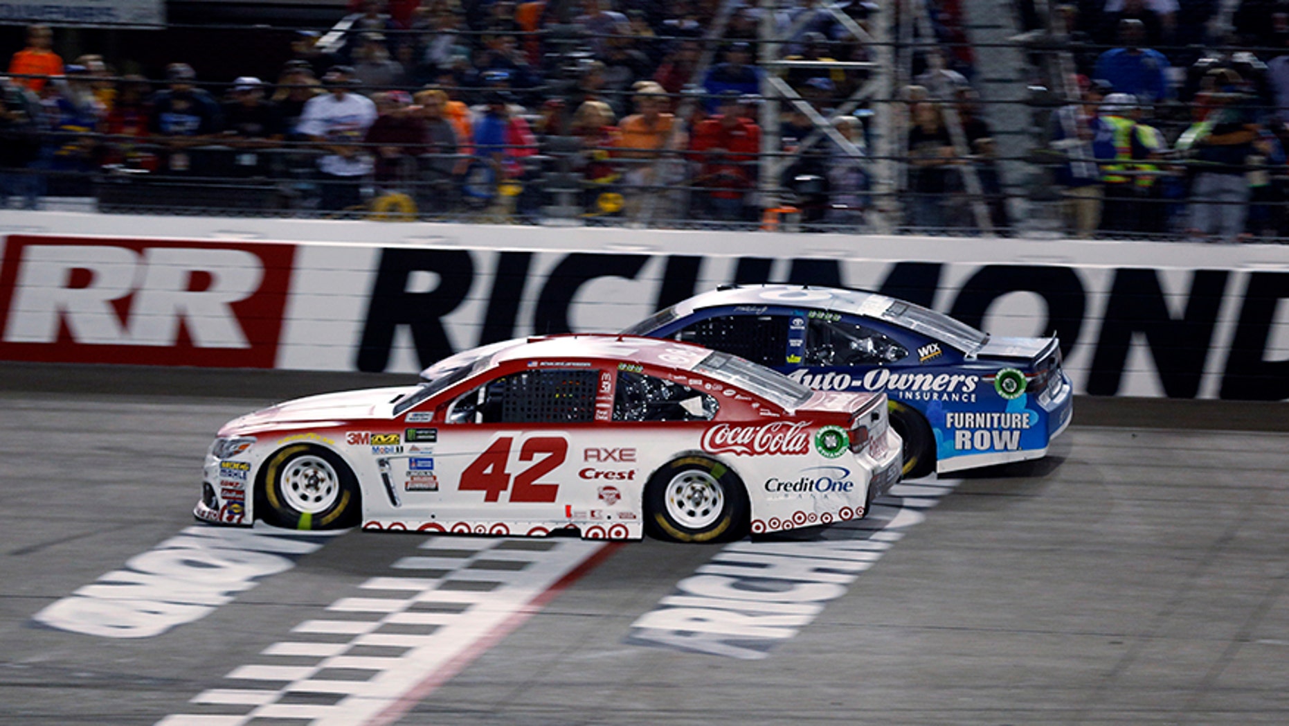 Kyle Larson (42) passes Martin Truex, Jr., (78) on the final restart to win the NASCAR Cup Series auto race at Richmond International Raceway in Richmond, Va., Saturday, Sept. 9, 2017. (AP Photo/Steve Helber)