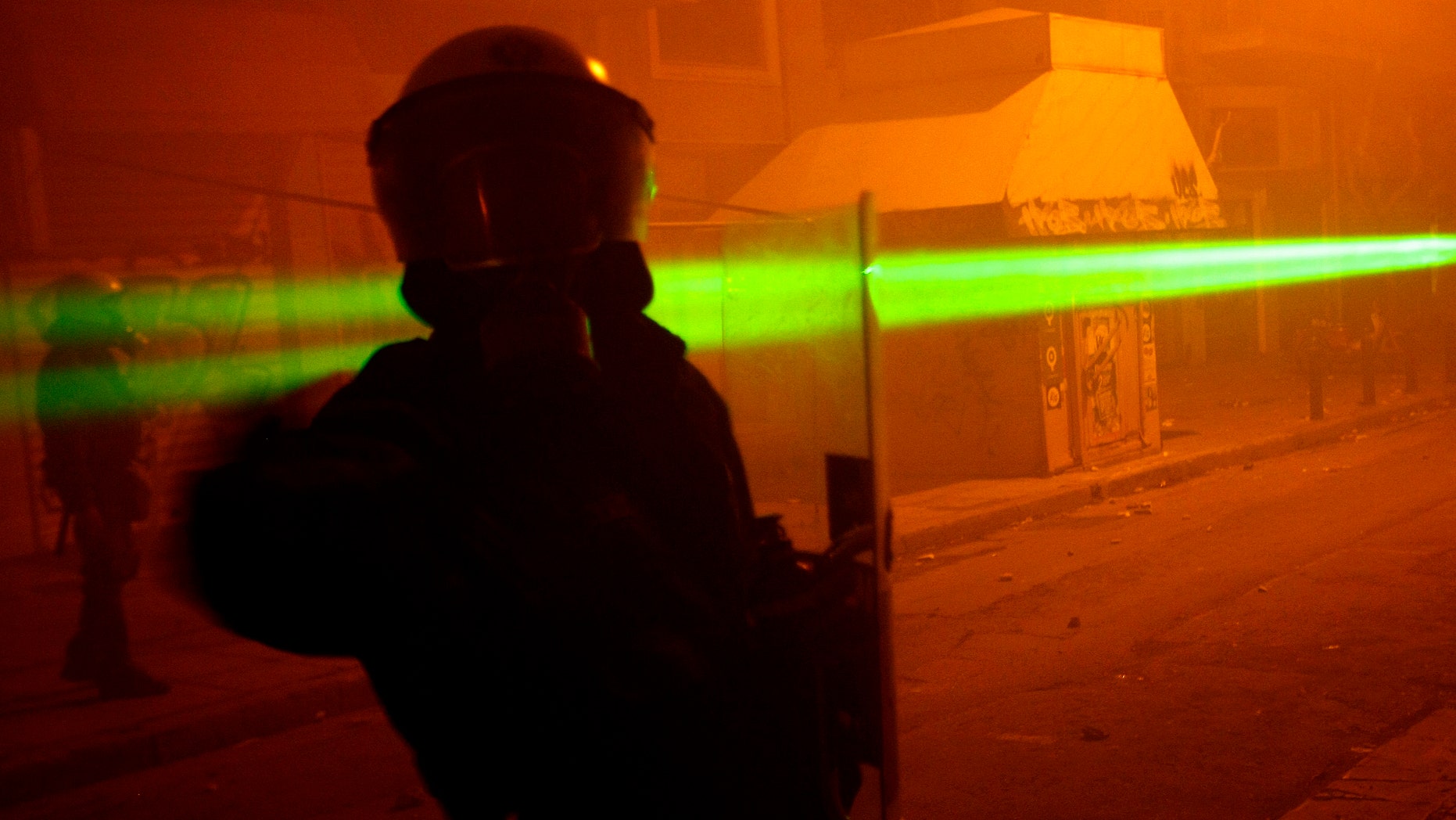 File photo - A riot policeman is aimed at with a laser light pointer during riots outside the Athens Polytechnic Dec. 14, 2008. (REUTERS/Yiorgos Karahalis)