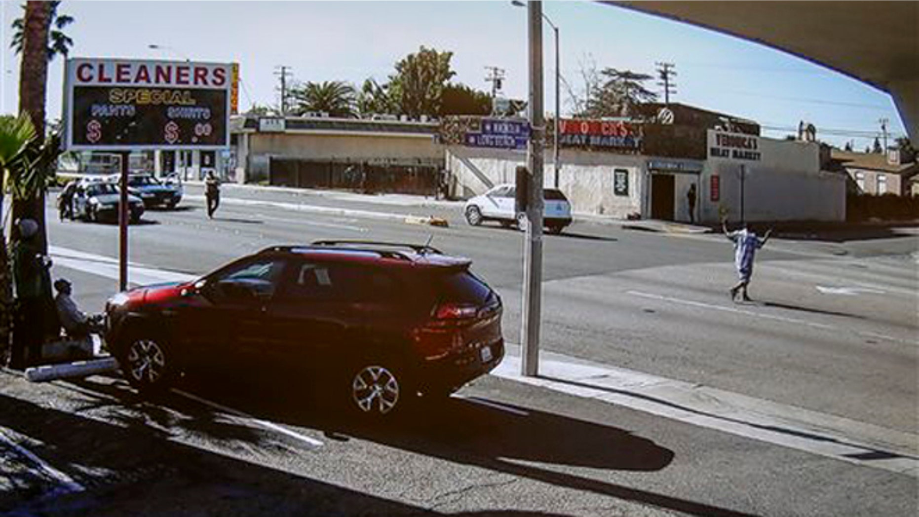 Dec. 12, 2015: In this image made from security video footage provided by the Los Angeles County Sheriff, a man, right, walks with a gun in his hand in Lynwood, Calif.