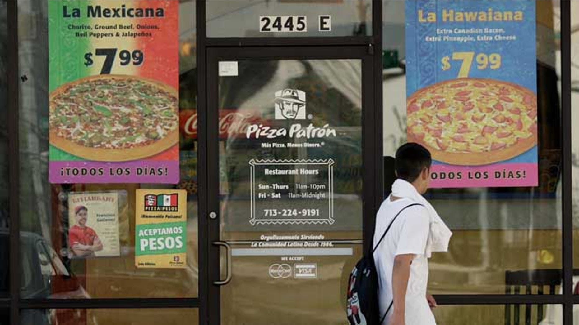 HOUSTON, TX - JANUARY 12: A boy passes a Pizza Patron January 12, 2007, in Houston. The pizza chain now accepts Mexican pesos and U.S. dollars as payment. (Photo by Dave Einsel/Getty Images)