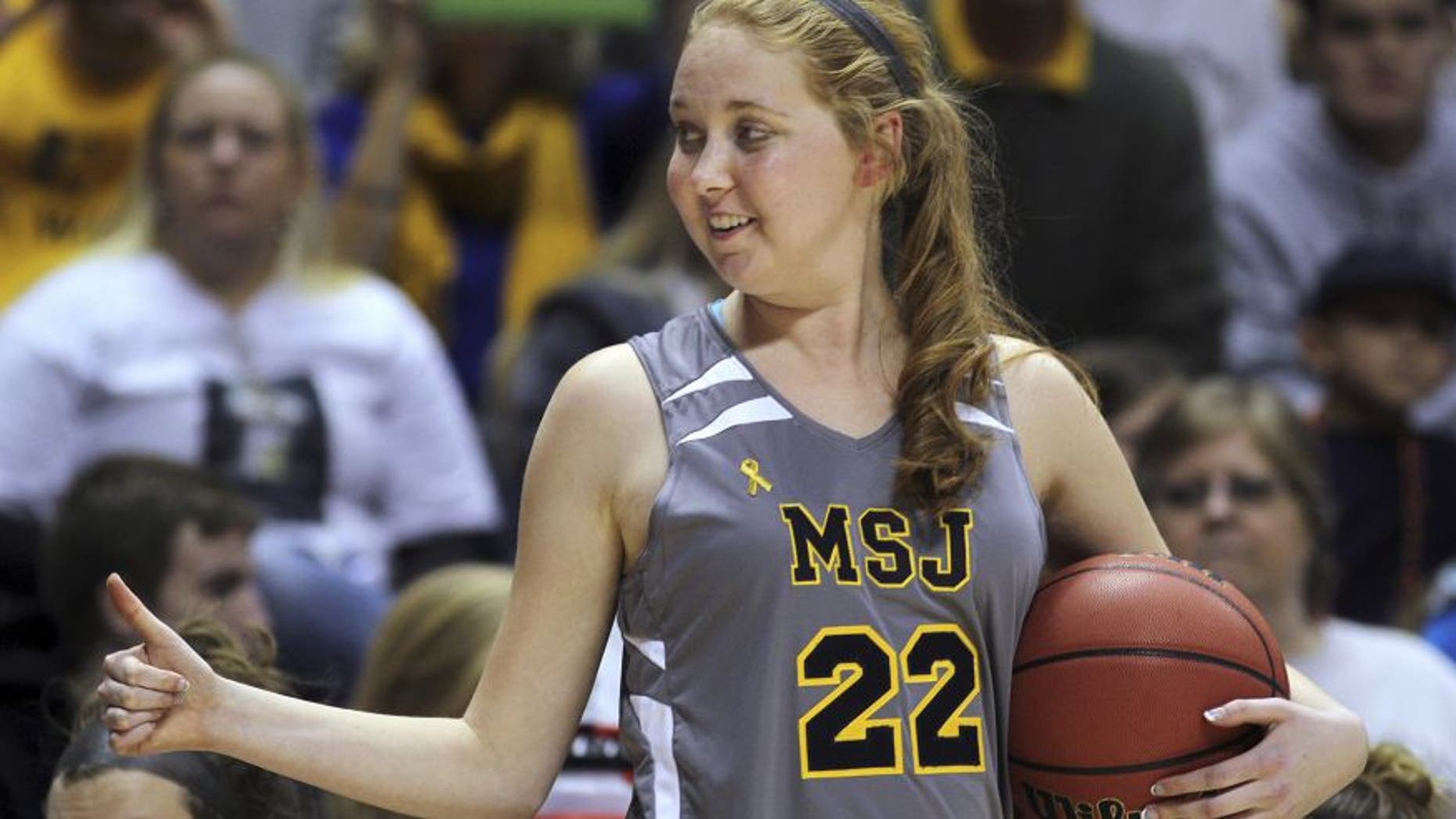 Nov. 2, 2014: In this file photo, Mount St. Joseph's Lauren Hill gives a thumbs-up as she holds the game ball during her first NCAA college basketball game against Hiram University at Xavier University in Cincinnati.