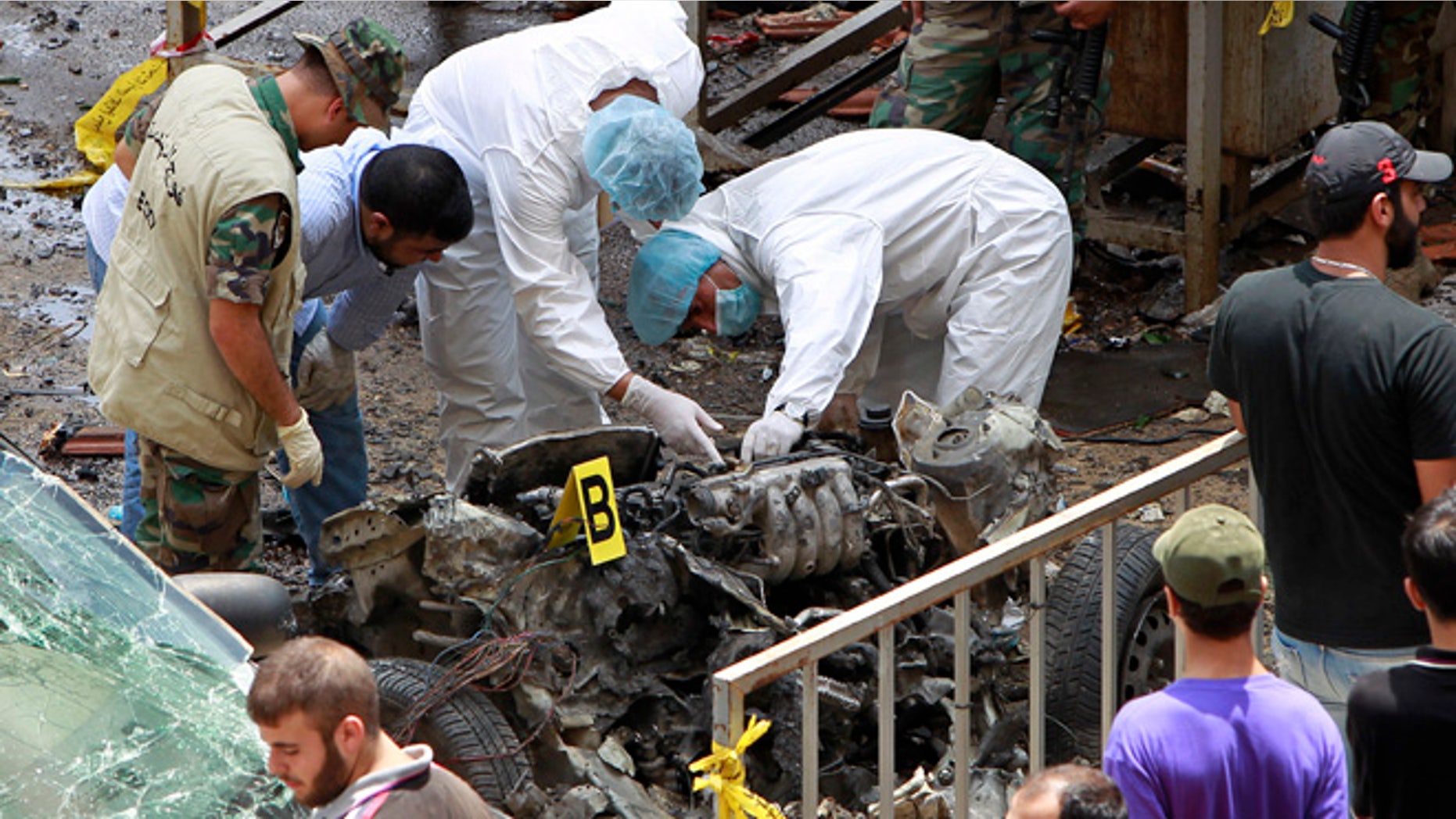 July 9, 2013: Forensic experts inspect the remnants of a car bomb at the scene of a bombing in the Beir el-Abed, a southern suburb of Beirut, Lebanon. A large explosion rocked a stronghold of the Shiite militant Hezbollah group south of the Lebanese capital Tuesday, setting several cars on fire, sending a thick plume of black smoke billowing into the sky and wounding more than a dozen people, security officials said.
