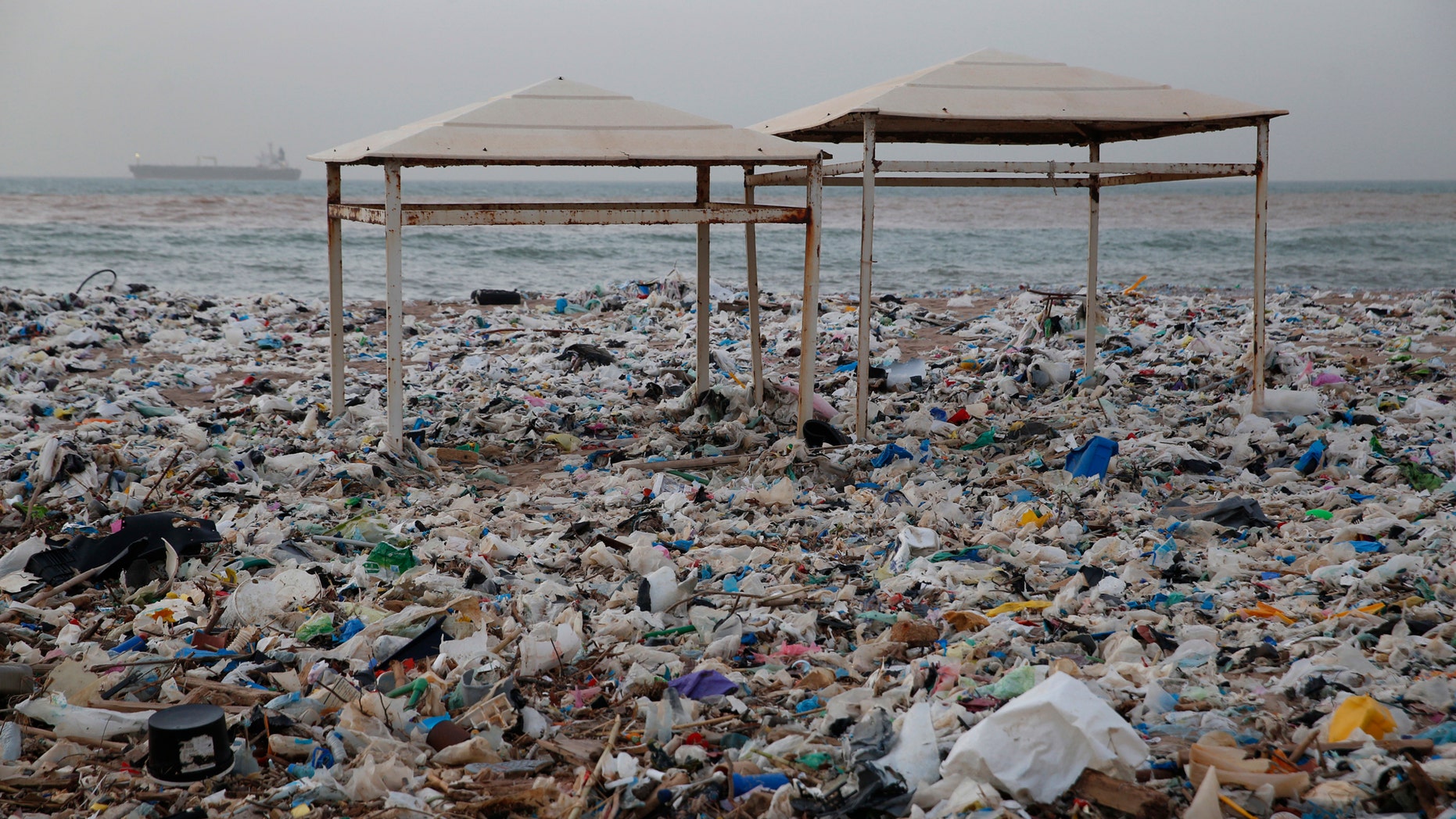In this Monday Jan. 22, 2018, photo, two tents sit in piles of garbage covering the shore days after an extended storm battered the Mediterranean country at the Zouq Mosbeh costal town north of Beirut, Lebanon. Environmentalists say a winter storm has pushed a wave of trash onto the Lebanese shore outside Beirut, stirring outrage over a waste management crisis that has choked the country since 2015. (AP Photo/Hussein Malla)