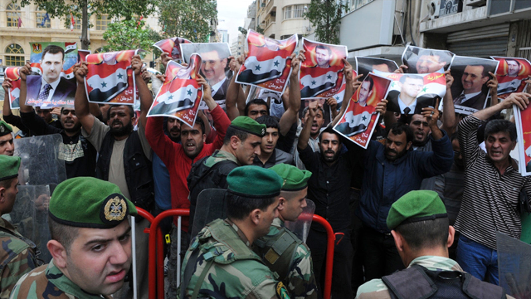 April 29: Lebanese soldiers stand guard as Syrian protesters carry pictures of Syrian President Bashar Assad and shout pro-government slogans in front of the Syrian embassy in Beirut, Lebanon. The banned Muslim Brotherhood urged Syrians to take to the streets on Friday as activists called for a "Day of Rage" against Assad's regime, which has stepped up its deadly crackdown on protesters by unleashing the army along with snipers and tanks. The Arabic on Assad's picture reads:" The crown of the nation." (AP)