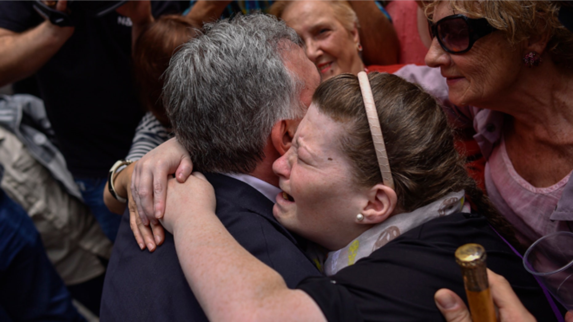 June 13, 2015: A woman cries as she embraces Pamplona's new Mayor and member of the Basque independence party EH Bildu, Joseba Asiron, left, in Ayuntamiento Square, in Pamplona, northern Spain. (AP)