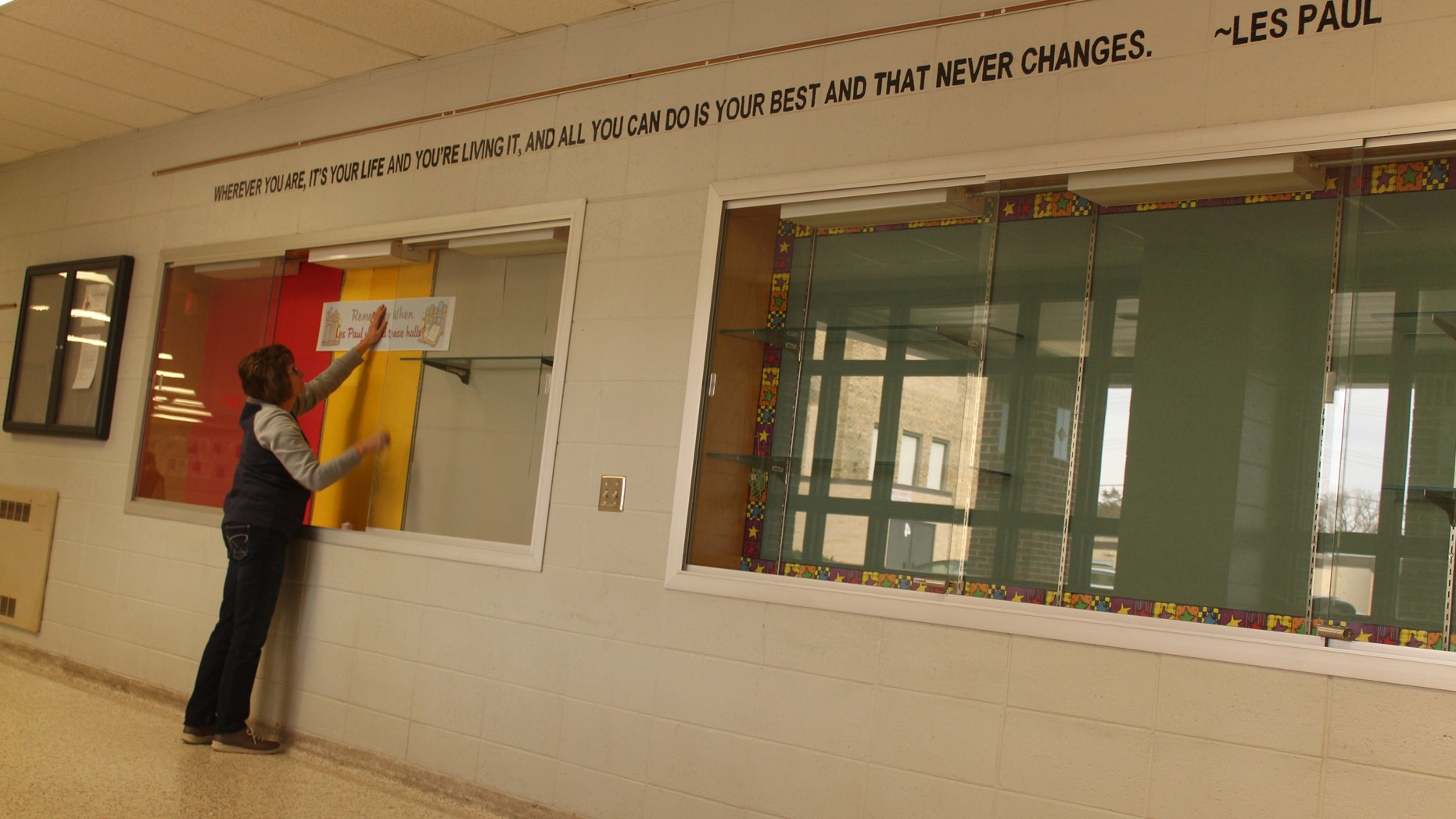 Nov. 7, 2014. A school official decorates a display case in anticipation of a school renaming ceremony for Les Paul in Waukesha, Wis. The school has been renamed from Central Middle School to Les Paul Middle School-Central Campus to honor the music icon.