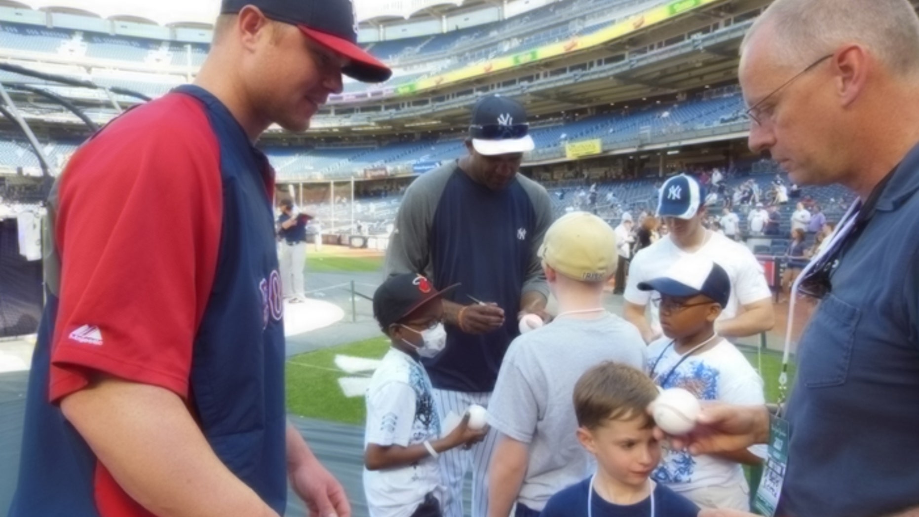 Red Sox ace Jon Lester makes time to sign autographs for kids with cancer, as does rival Yankees pitcher CC Sabathia (background).