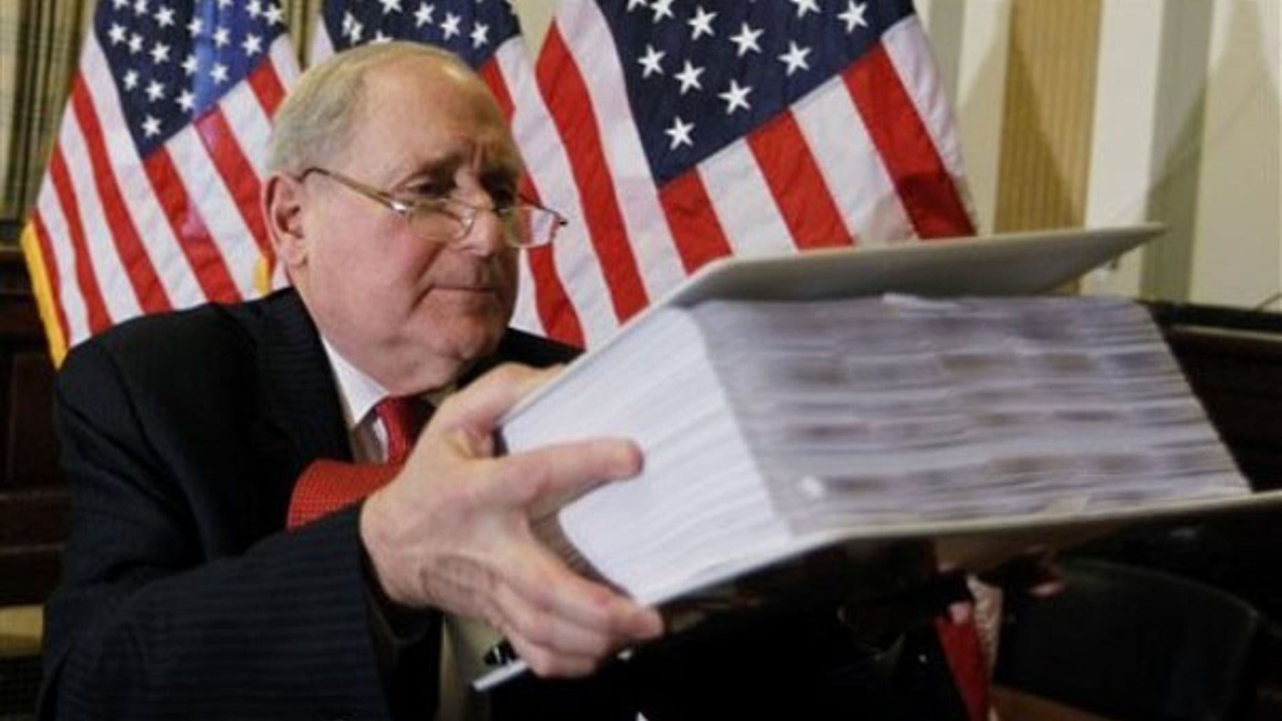 Sen. Carl Levin lifts documents on the role of investment banks in the Wall Street financial crisis as he briefs reporters on Capitol Hill April 26 ahead of the Goldman Sachs hearings. (AP Photo)