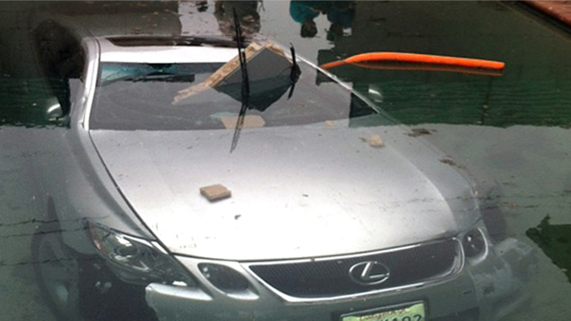 May 13, 2012: In this photo provided by Beatriz Diaz, officials investigate the scene where a man crashed his car through a wall and into a swimming pool in La Puente, Calif., early Sunday morning.