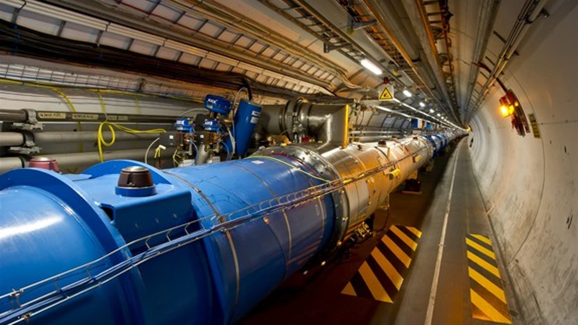 This photo shows the tunnel of the Large Hadron Collider, where beams of particles pass through the central pipes before colliding with each other.
