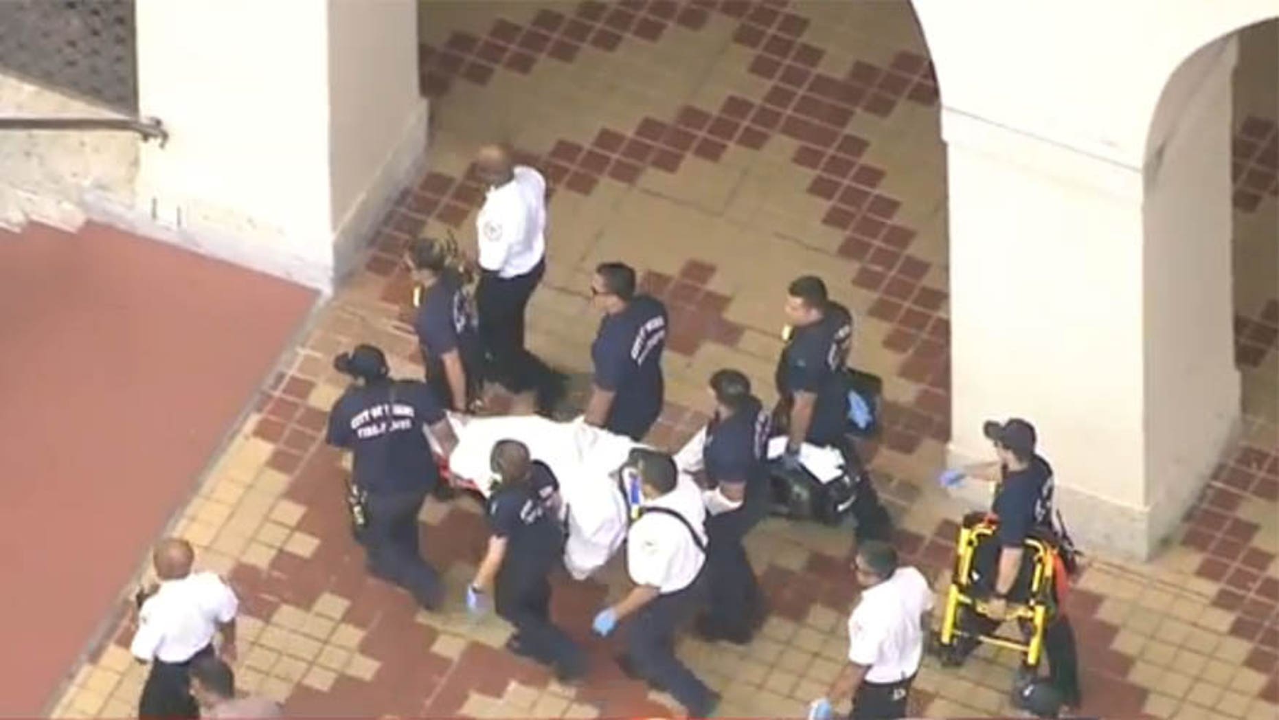 May 3, 2017: An injured suspect is carried away by responders after shots were fired inside the Miami-Dade Library.