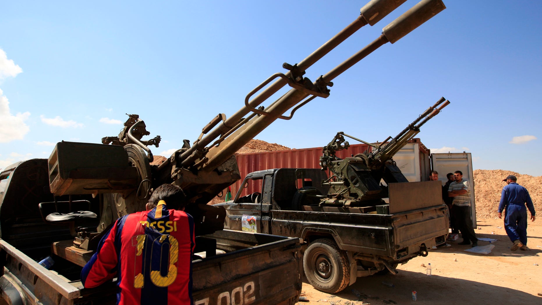 Tuesday: A Rebel fighter wearing FC Barcelona soccer player Lionel Mess T-shirt stands next to his heavy weapon, preparing for clashes with pro-Muammar al-Qaddafi forces at the front line of Dafniya, about 25 miles west of Misrata, Libya.