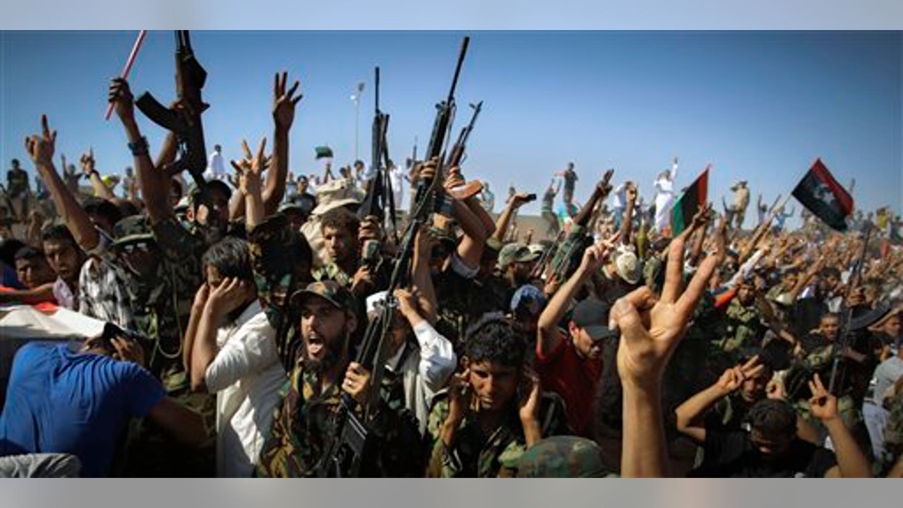 July 29: Libyan men salute and chant slogans during funeral of the Libyan rebels' slain military chief Abdel-Fattah Younis in the rebel-held town of Benghazi, Libya. Thousands of mourners marched in the funeral procession Friday for the Libyan rebels' slain military chief, a day after he was gunned down under still mysterious circumstances. Abdel-Fattah Younis was killed as he traveled from his front lines operations room to the rebels' de facto capital Benghazi.