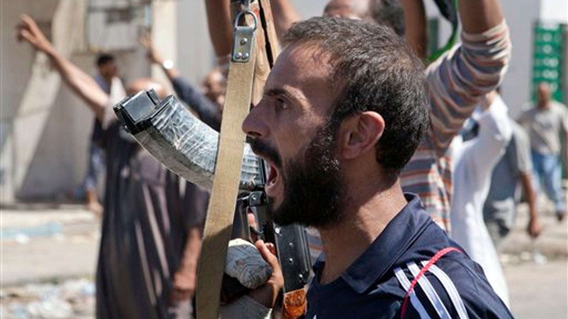 Aug. 14: In this photo, a Libyan rebel fighter in Zawiya, western Libya, reacts to the news that the city of Surman, an important strategic point, is now under the control of the rebel forces. Libyan rebels have claimed they were trying to cut off two key supply routes to Muammar al-Qaddafi's stronghold in Tripoli after capturing more towns in the west of the country.