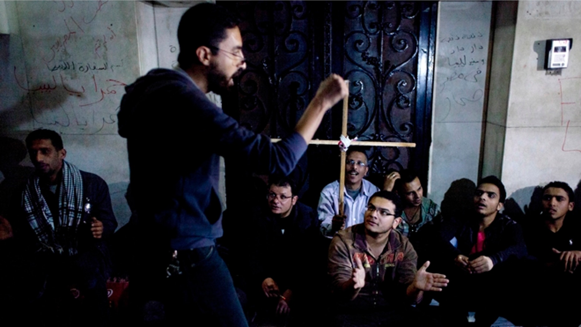 Egyptian protesters sit near Libyan embassy during demonstration condemning the death of Egyptian Christian Ezzat Atallah at a Libyan prison earlier this month. Four Christians remain imprisoned in Libya, including an American (AP Photo/Nasser Nasser)