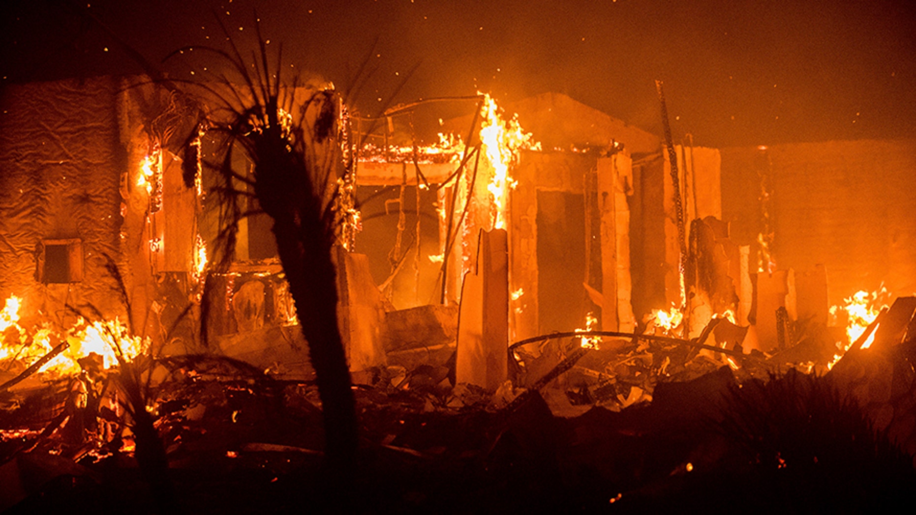 Flames consume a structure as the Lilac fire burns in Bonsall, Calif.