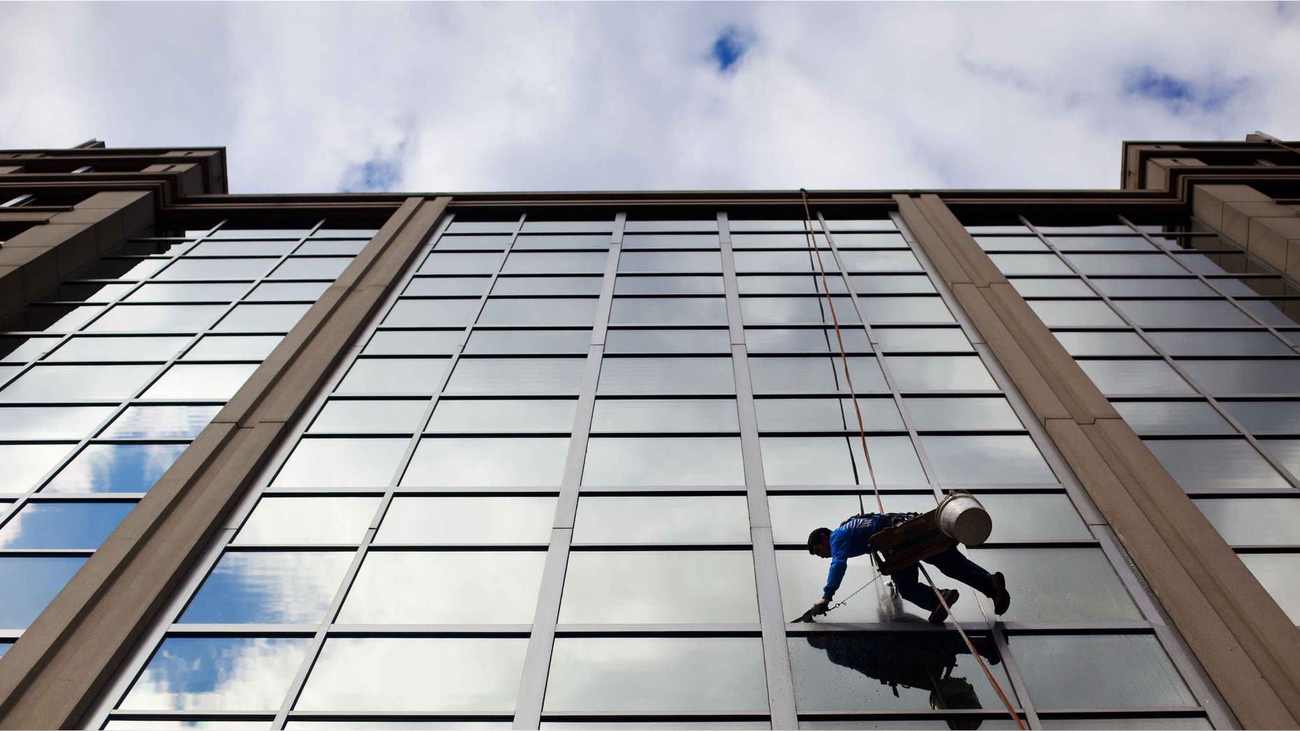 FILE - In this April 23, 2015 file photo, a window washer cleans the windows of an office building in downtown Washington. The U.S. government issues the May jobs report on Friday, June 5, 2015. (AP Photo/Pablo Martinez Monsivais, File)
