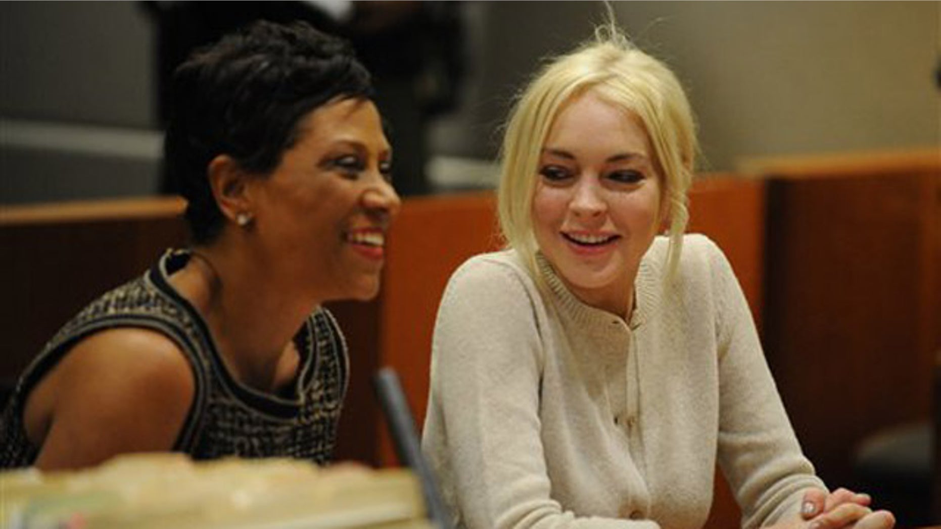 Lindsay Lohan, right, alongside her attorney Shawn Chapman Holley are seen during progress report session at the Los Angeles Superior Court Wednesday, Dec. 14, 2011 in Los Angeles. A judge says Lindsay Lohan is doing well under her strict new probation routine of counseling and working at the county morgue. Lohan remains on probation for a 2007 drunken driving and a grand theft case filed earlier this year. (AP Photo/Michael Nelson, Pool)