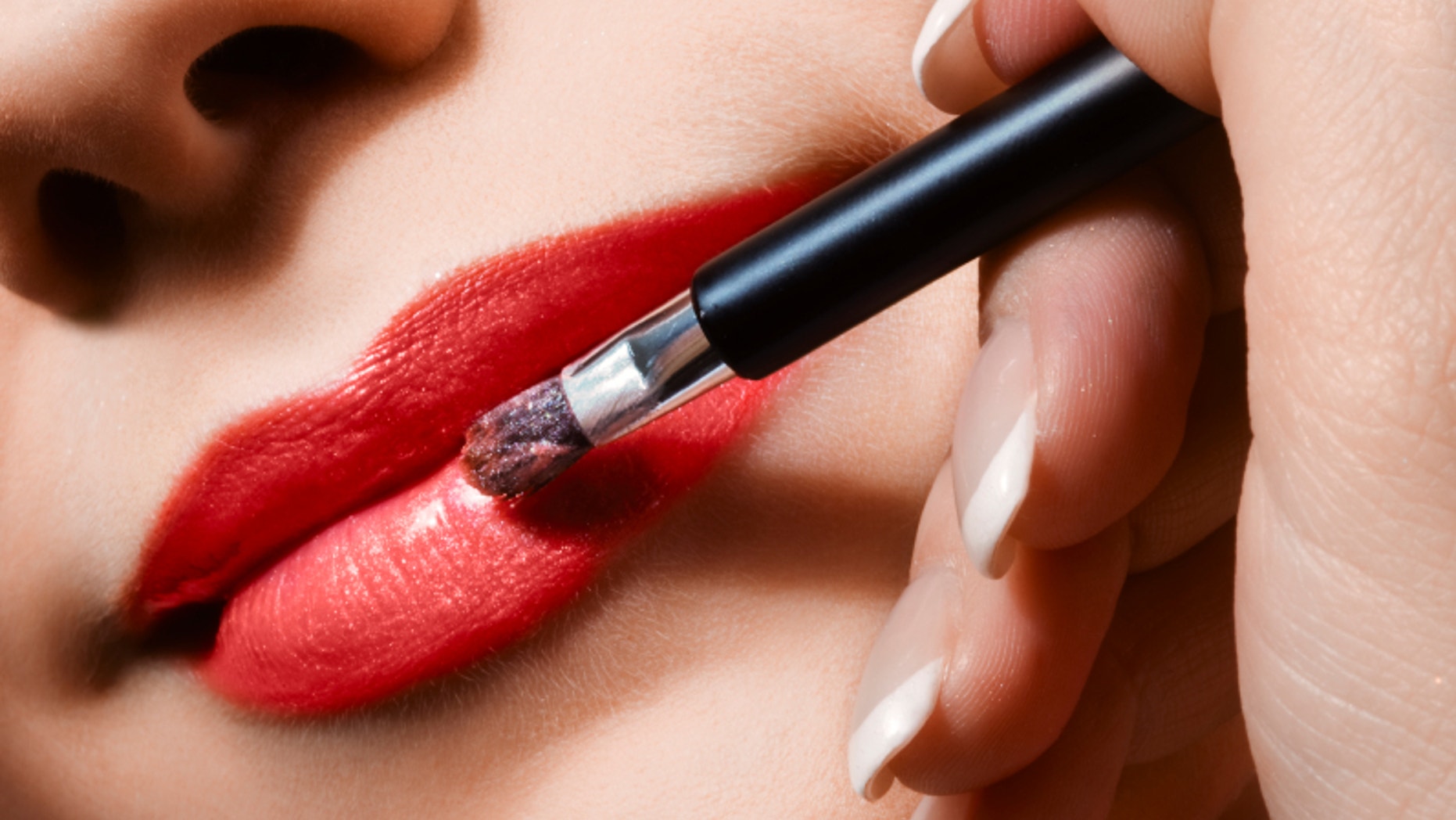 woman applying lipgloss on lips