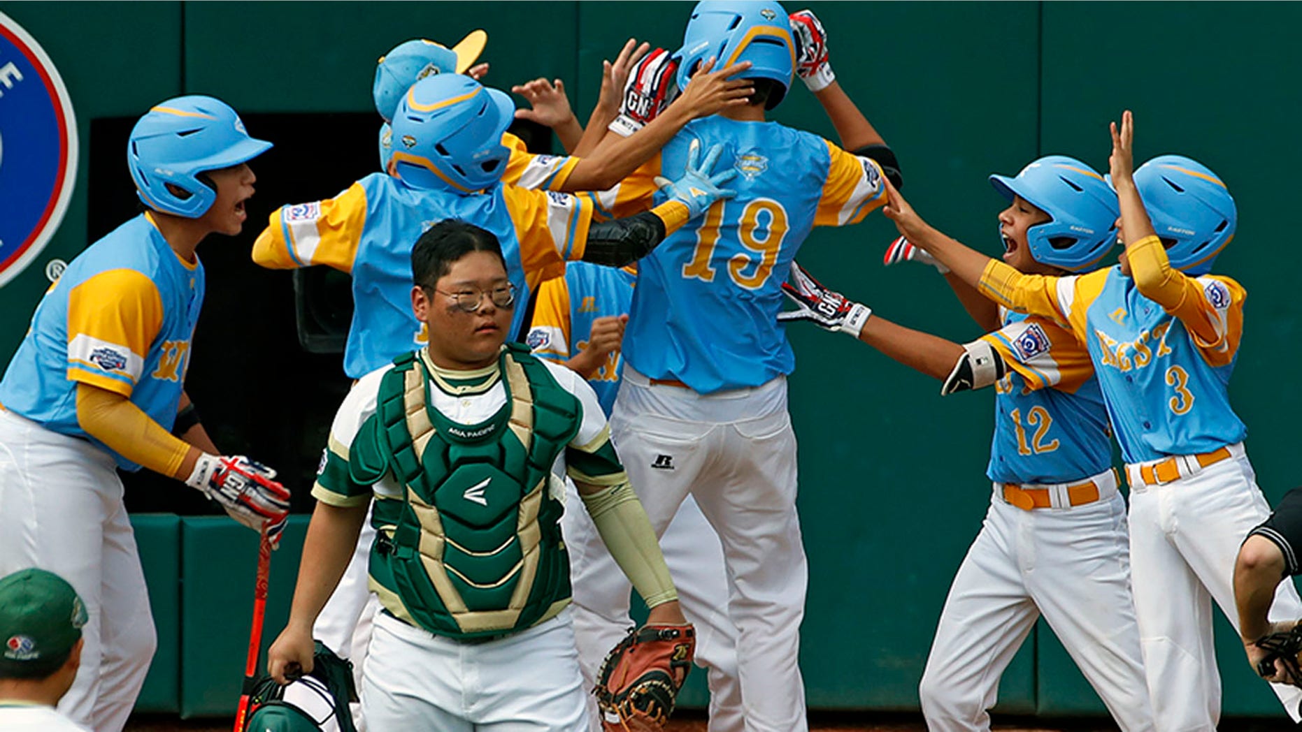 Mana Lau Kong (19) celebrates with his teammates after hitting a home run in the bottom of the first inning of Sunday's Little League World Series Championship game.