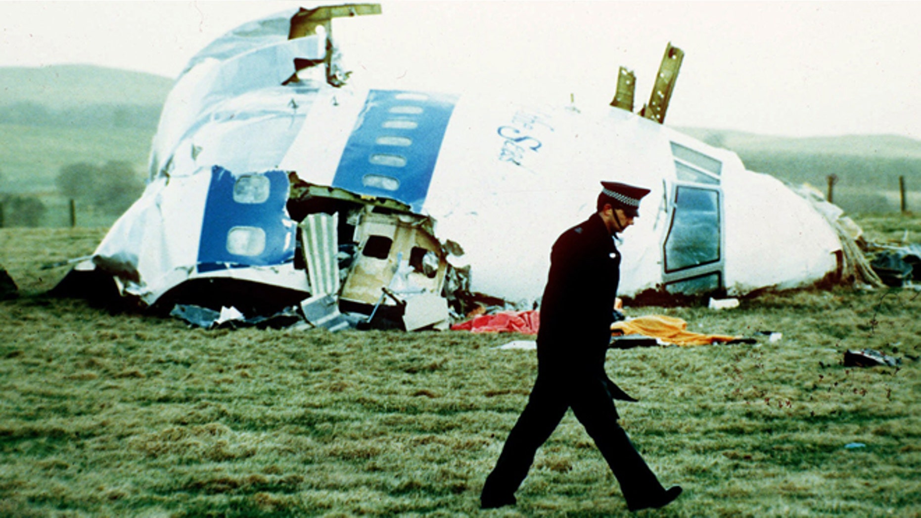 Un policÃa pasa frente a los restos del avión de Pan Am en Lockerbie, Escocia, el 21 de diciembre de 1988. Abdel Baset al-Megrahi, un libio encontrado culpable del atentado donde murieron 270 personas, murió a los 60 años debido al cáncer, se informó el domingo 20 de abril de 2012. (Foto AP/Martin Cleaver, Archivo)