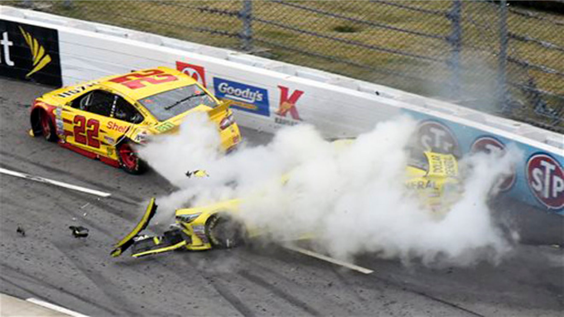 Joey Logano (22) and Matt Kenseth (20) tangle in Turn 1 during the NASCAR Sprint Cup Series auto race at Martinsville Speedway in Martinsville, Va., Sunday, Nov. 1, 2015. (AP Photo/Don Petersen)
