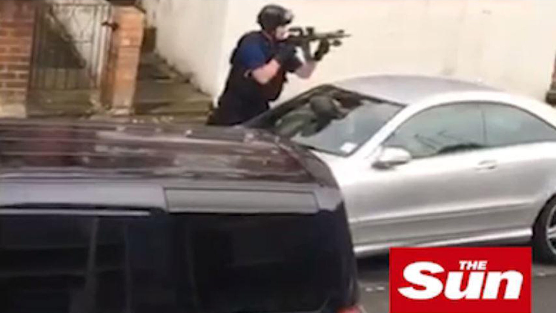 An armed cop is seen during a police raid in Willesden, northwest London