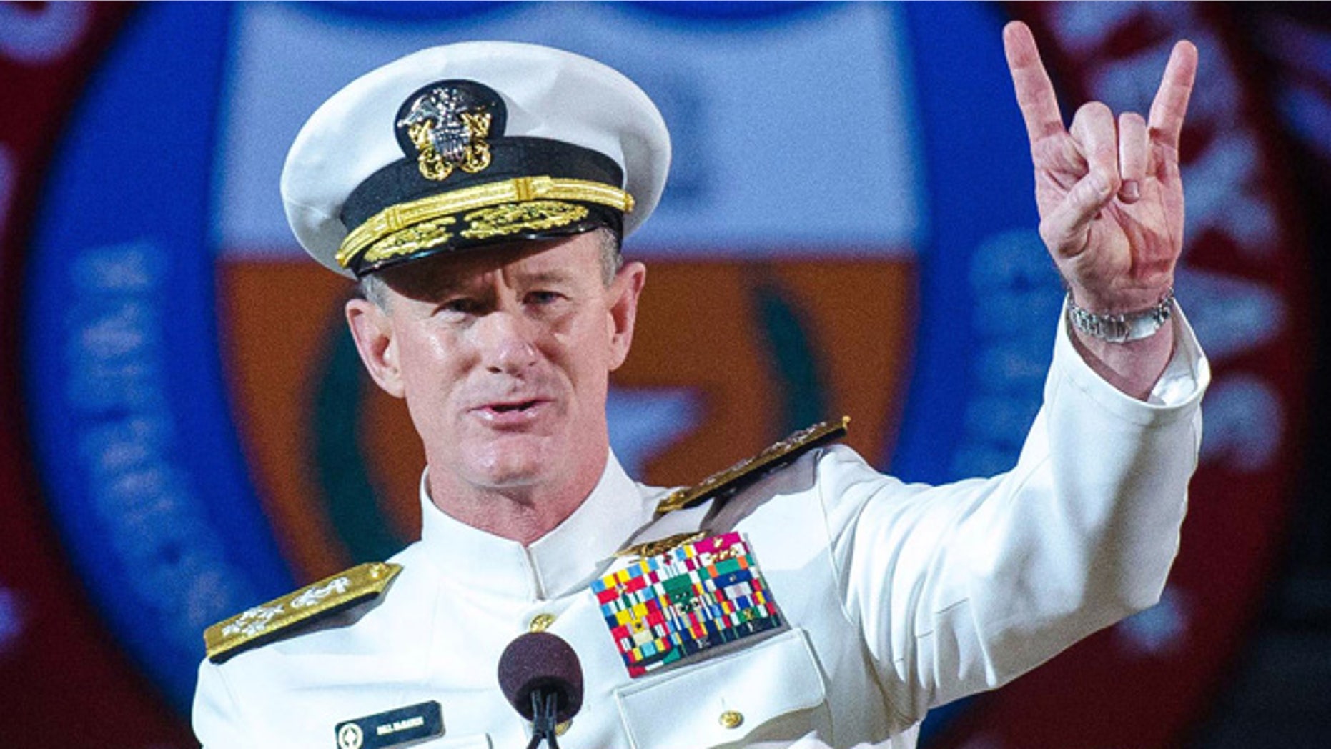FILE - In this May 17, 2014 file photo Naval Adm. William H. McRaven, an alumnus, does the Longhorns' Hook 'em Horns hand signal during his commencement keynote address at the University of Texas in Austin. The University of Texas System regents on Tuesday, July 29, 2014, selected McRaven as the lone finalist for the job of chancellor, overseeing the systems 15 campuses and $14 billion budget. (AP Photo/ The University of Texas at Austin, Marsha Miller, File)