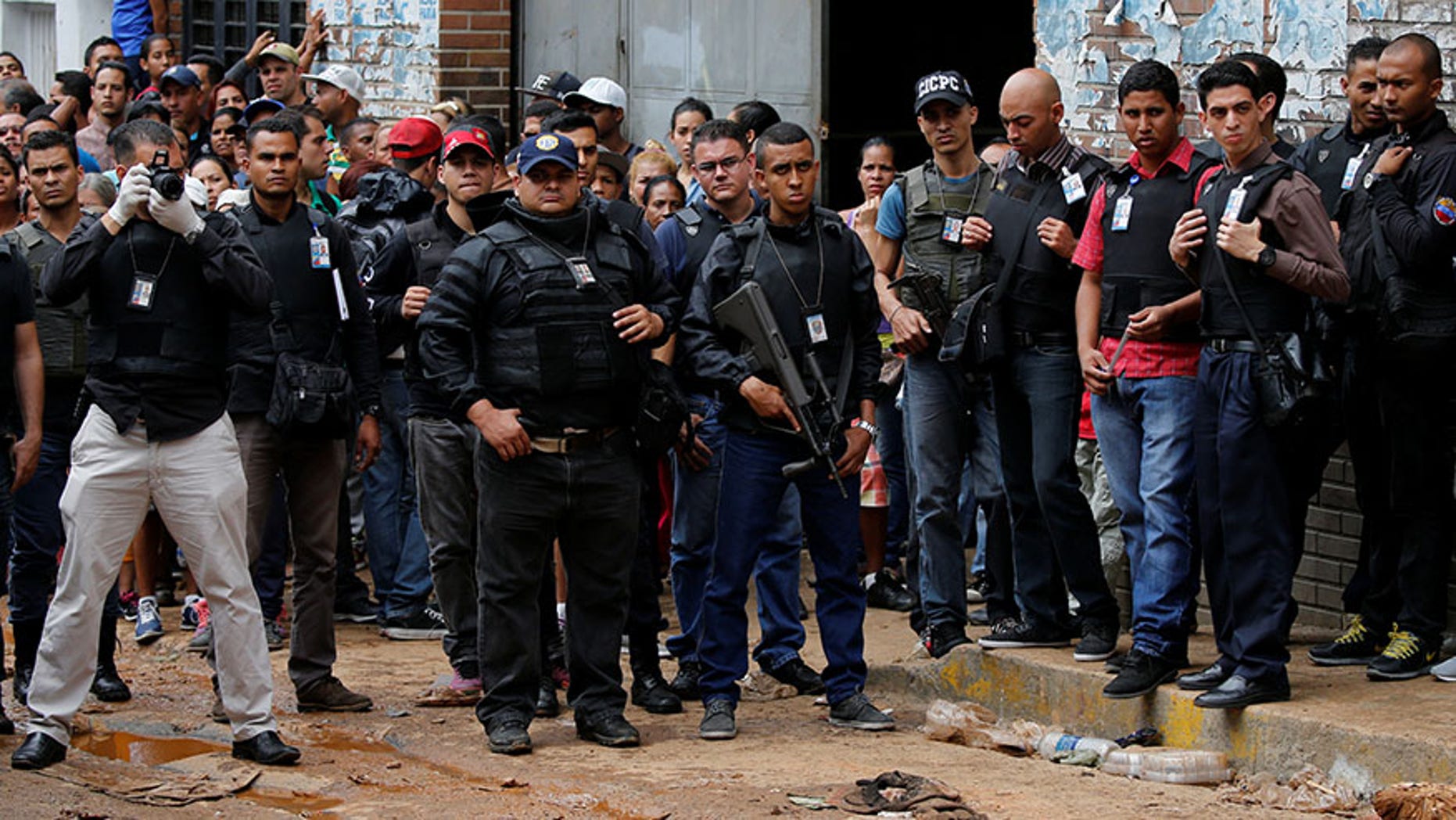 Police officers and criminal investigators look for evidence in front of a bakery after it was looted in Caracas, Venezuela April 21, 2017.