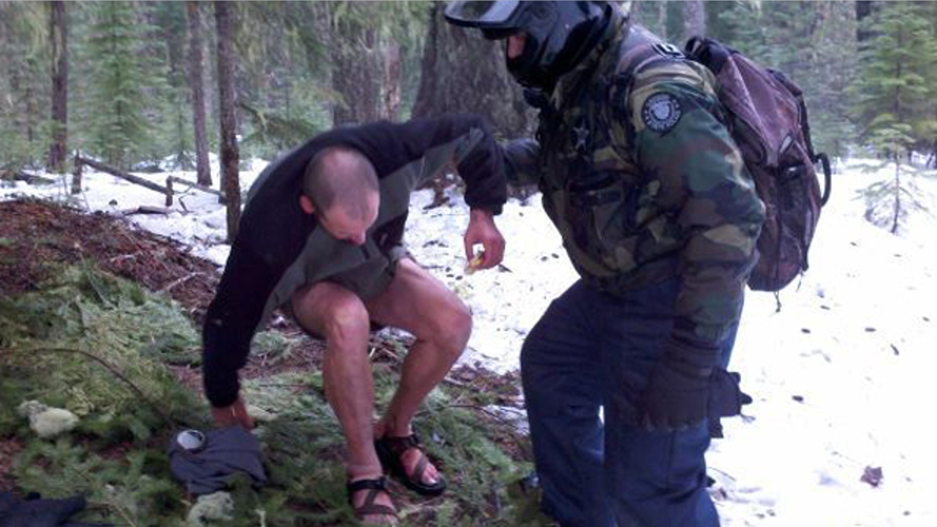 Feb. 9, 2012: Senior Trooper Don Frerichs lends a hand to Jason D. Cooper, 37, after he was discovered beneath pine boughs in an attempt to keep warm in remote area of Oregon's Douglas County.