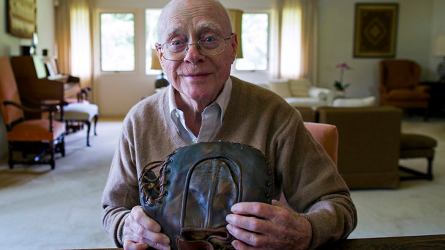 June 30, 2014: Howard Henderson, who as a boy in New York played catch with baseball legend Lou Gehrig, holds a signed baseman's mitt given to him by Gehrig when he was young, at Henderson's Greenwich, Conn., home.