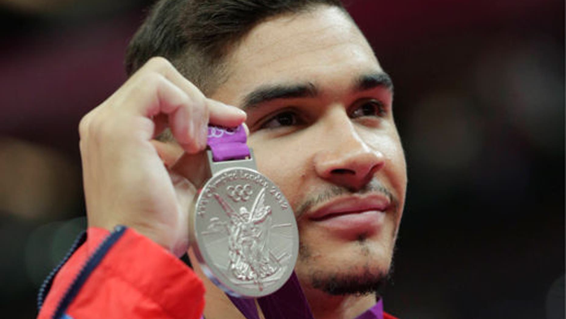 Louis Smith displays his silver medal during the artistic gymnastics men's pommel horse finals at the 2012 Summer Olympics.