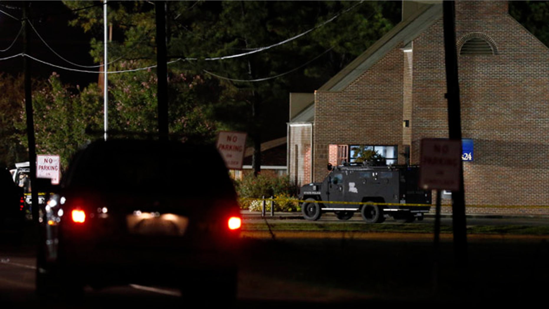 Aug. 14, 2013: Police drive past the Tensas State Bank branch in St. Joseph, La., early Wednesday morning in St. Joseph, La., where a gunman took three people hostage Tuesday.