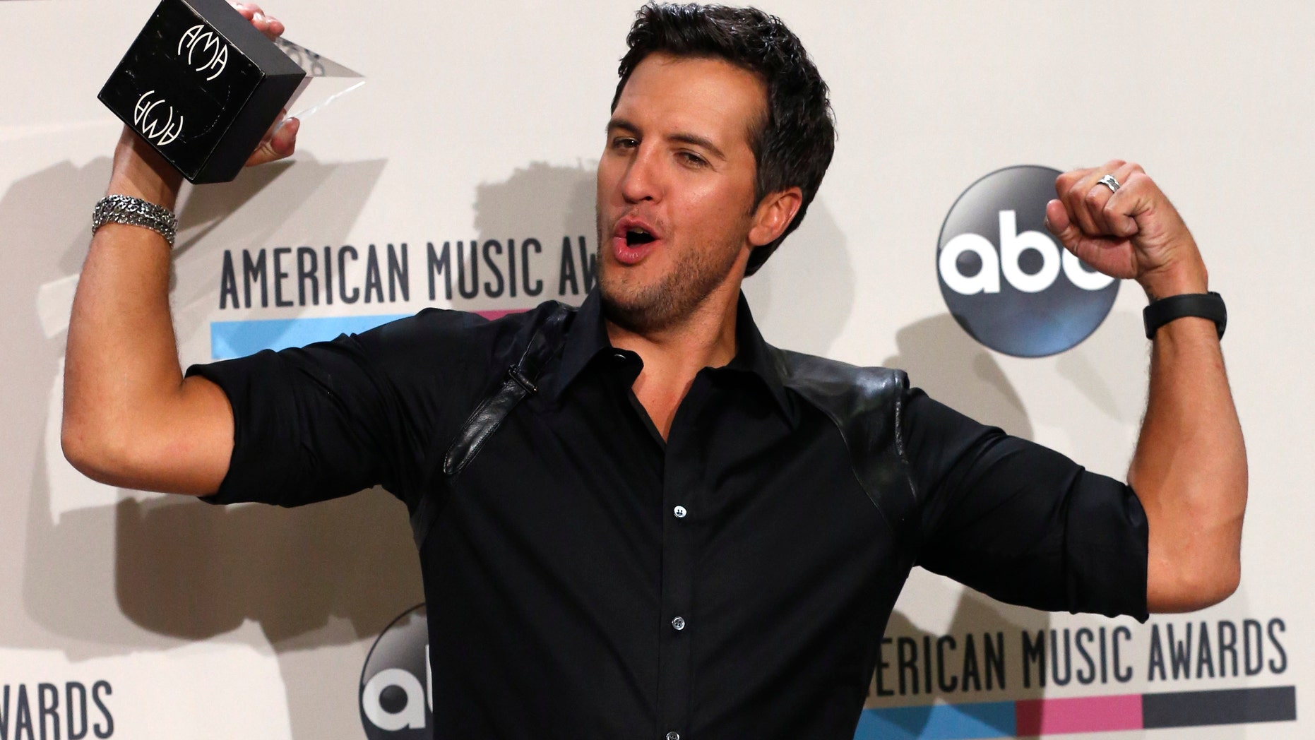 November 24, 2013. Luke Bryan poses with his award for favorite country male artist at the 41st American Music Awards in Los Angeles, California.