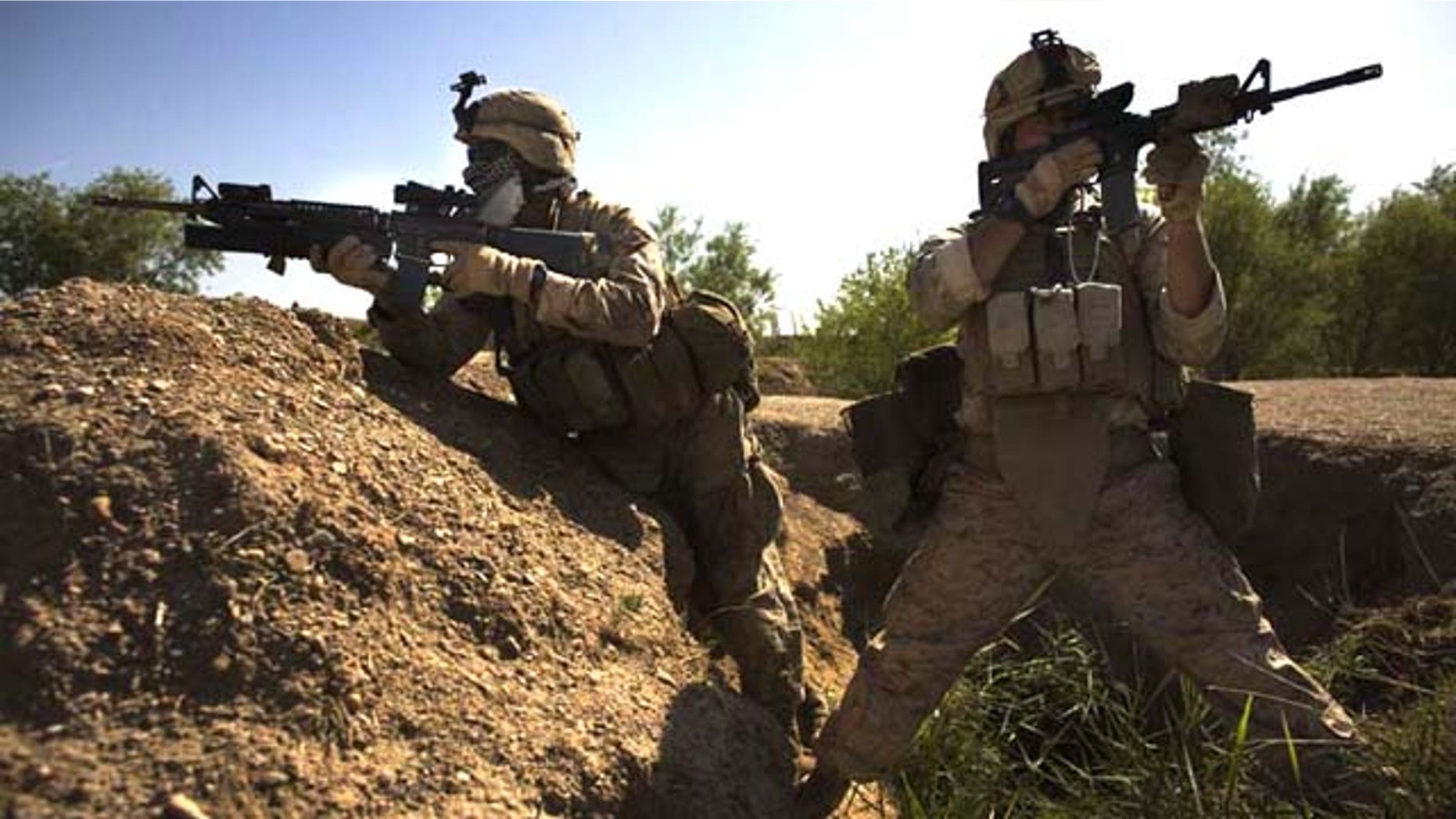 Navy corpsman Michael Lang, of Camden County, Ga., right, with an M-4 carbine, and Lance Cpl. Ard Bizahaloni of Pinon, Ariz., with an M-16 rifle, with the First Battalion, Sixth Marine Regiment, Alpha company, take up positions in Marjah, Afghanistan. The U.S. military's workhorse rifle, used in battle for the last 40 years, may be proving less effective in Afghanistan.