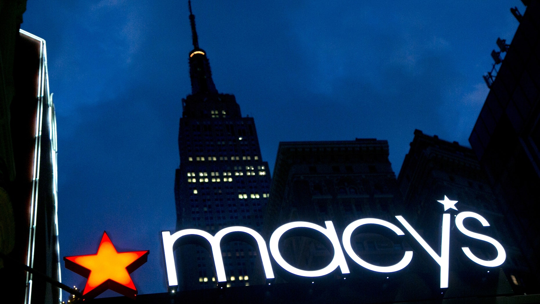The Macy's logo is illuminated with the Empire State Building in the background