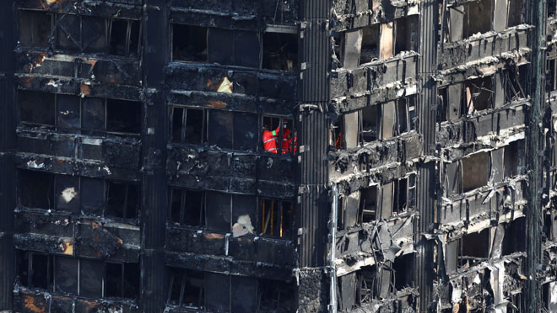 Members of the emergency services work inside burnt out remains of the Grenfell apartment tower in North Kensington, London, Britain, June 18, 2017. REUTERS/Neil Hall - RTS17KNS