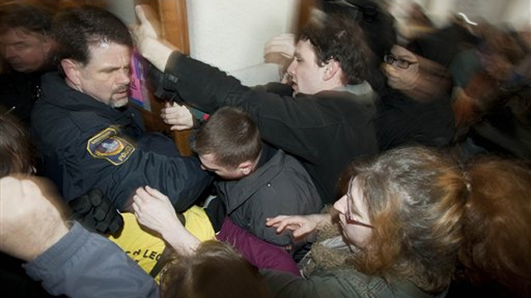 Police try to secure a door during a protest at the Wisconsin state Capitol March 10 in Madison.